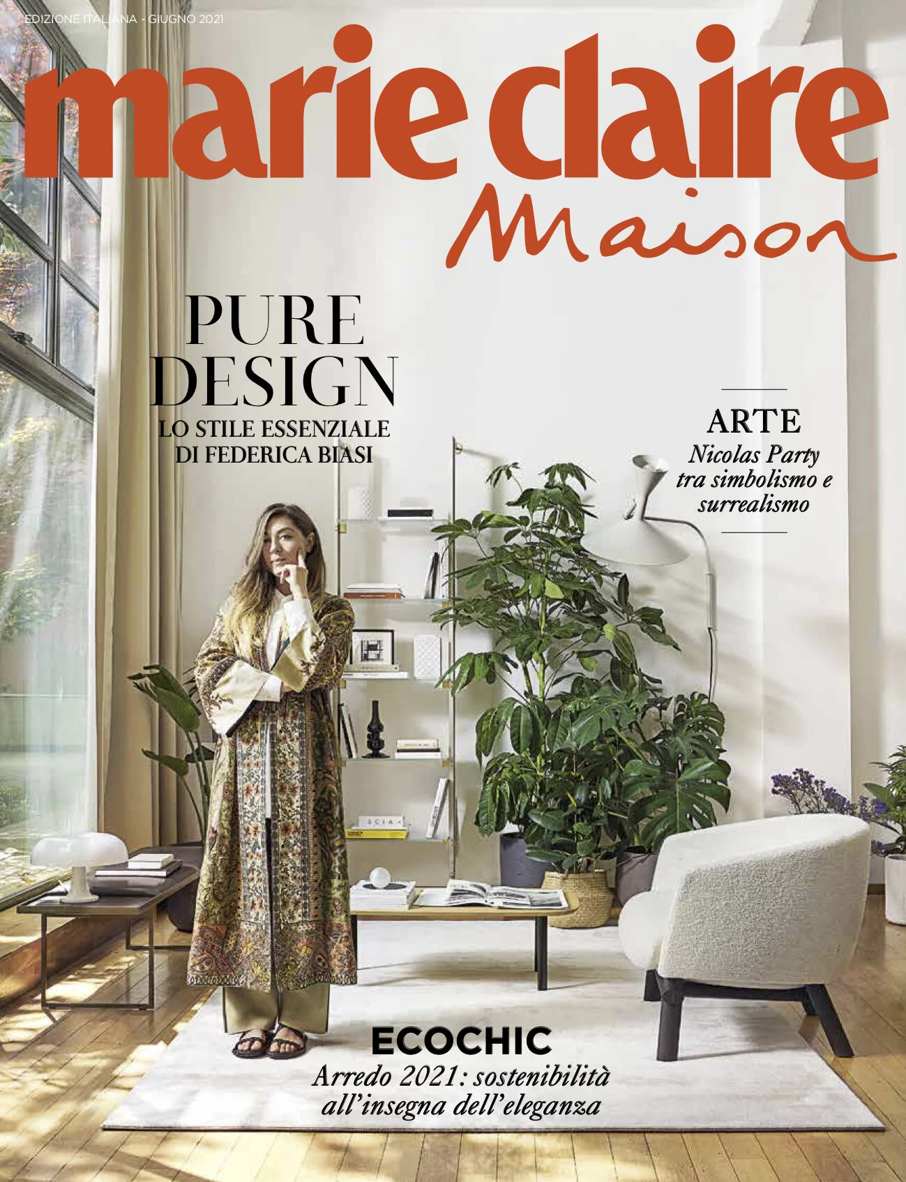 Cover of Marie Claire Maison magazine featuring a woman standing in a minimalist living room with large green plants, a white armchair, a wooden coffee table, and bookshelves. The magazine text highlights pure design, art, and sustainability.