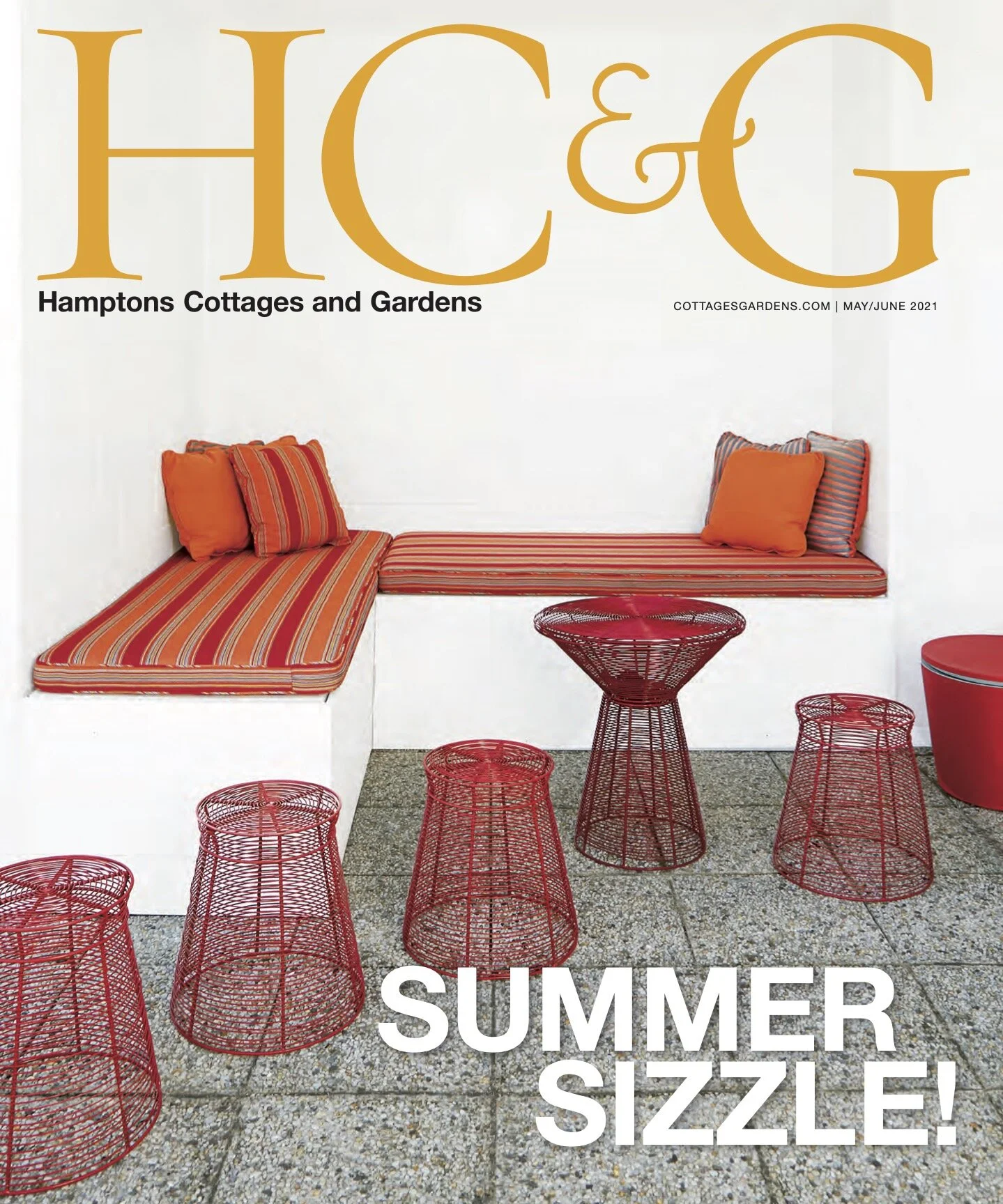 Cover of Hamptons Cottages and Gardens magazine, May/June 2021 issue, featuring a patio scene with a built-in white bench with striped orange and red cushions, six red wire side tables, a round red table, and a red plastic bucket, with the headline "