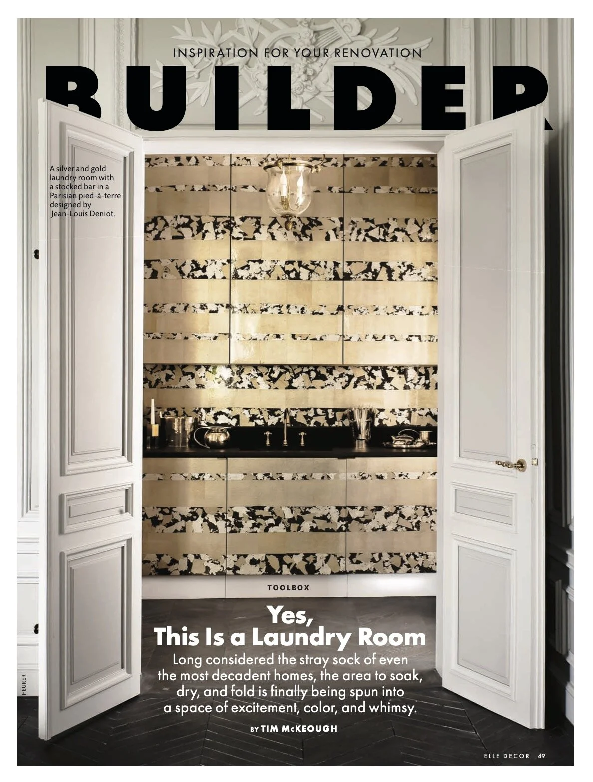Interior view of a laundry room with a textured gold and black patterned wall, open white double doors, and a black countertop with a sink and decorative items.