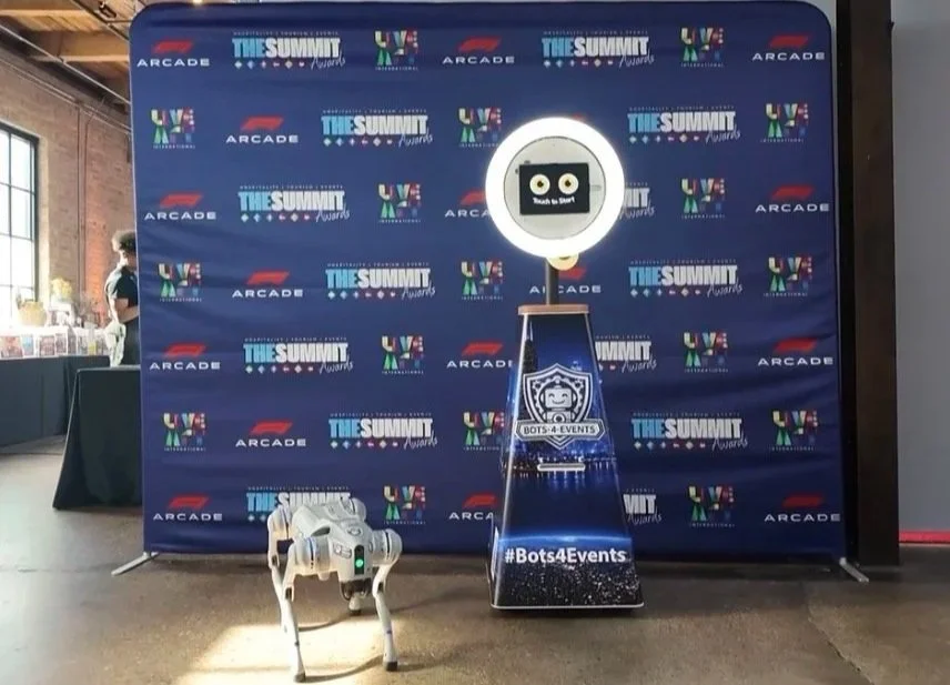 Photo of  Eve The Robot Dog and SelfieBot at an event.