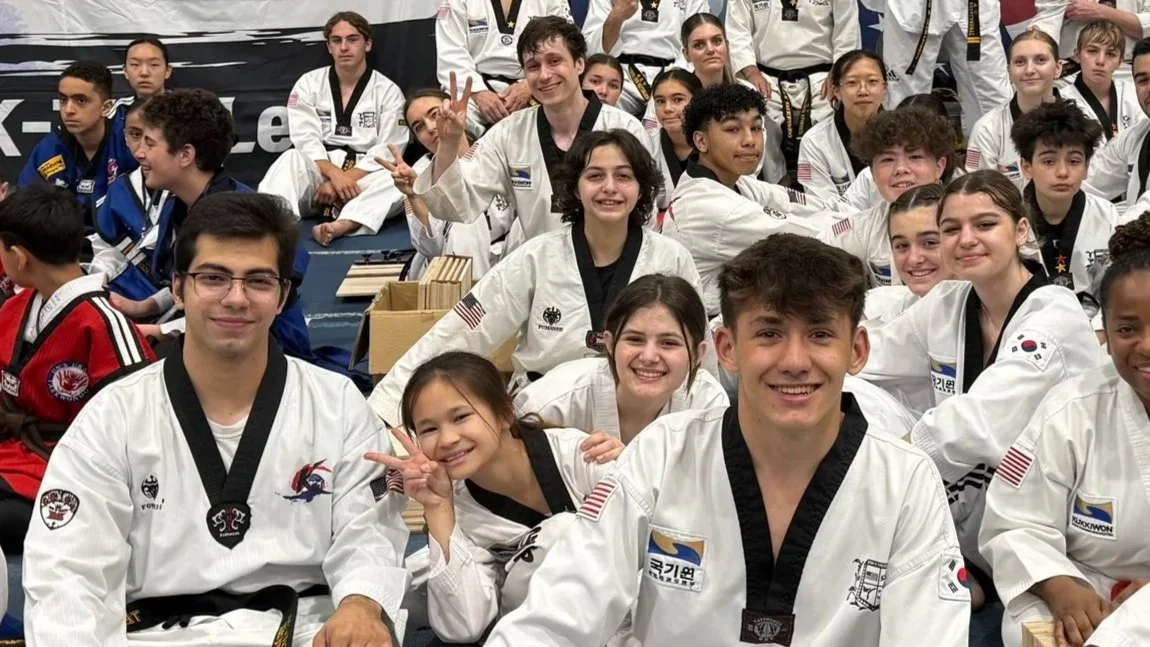 Group of young martial artists wearing gis at a tournament or training event.