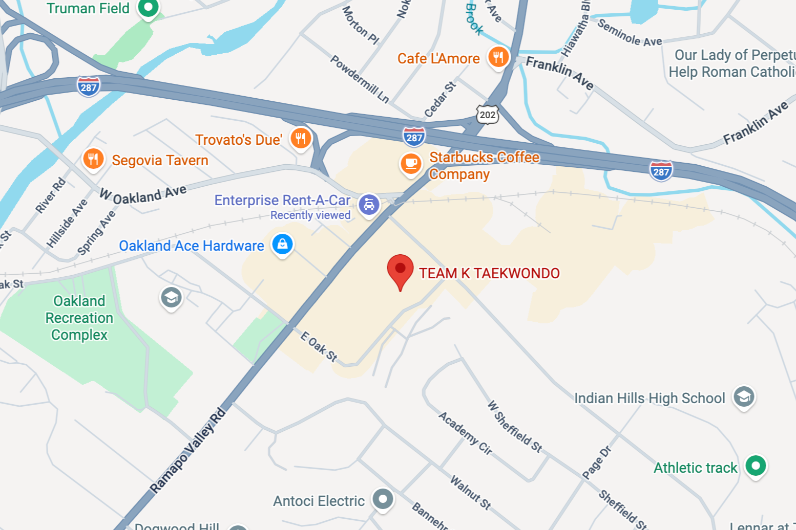 Map showing locations in Oakland, including TEAM K TAEKWONDO marked by a red pin, nearby businesses such as Starbucks Coffee, Trovato's Deli, and Segovia Tavern, and landmarks like Oakland Recreation Complex, Indian Hills High School, and athletic track. Nearby roads include Interstate 287, Ramapo Valley Road, and Franklin Avenue.