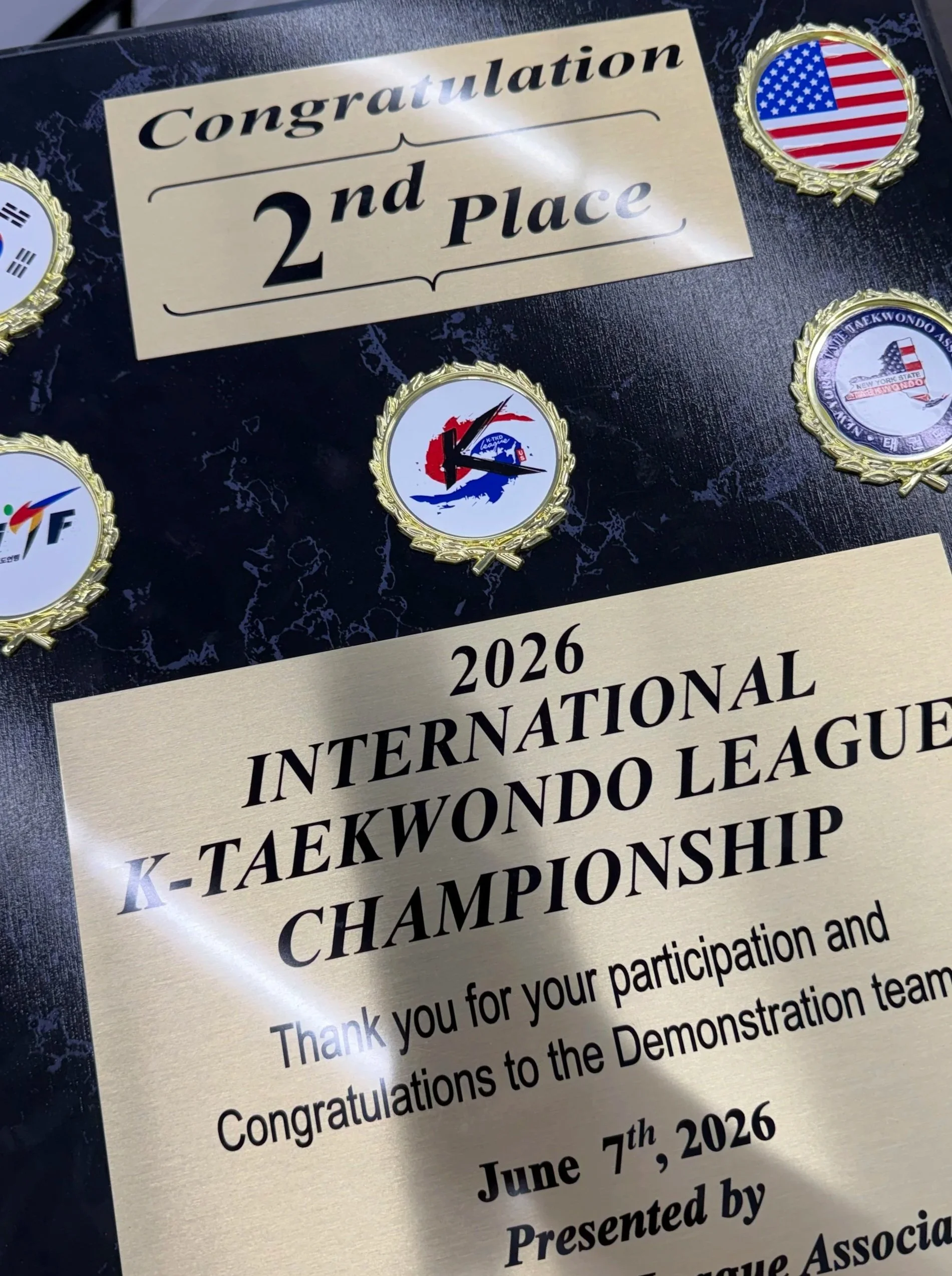 Certificate for 2nd place at the 2026 International Taekwondo League K-Taekwondo Championship with medals featuring flags of the United States, South Korea, and other countries.