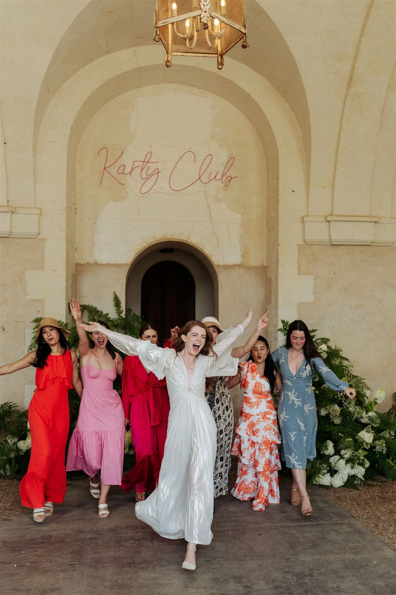 A group of women celebrating and dancing in front of Chateau de Grand Luce.