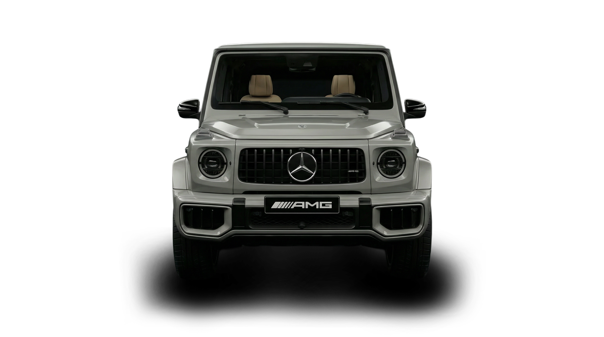 Front view of a silver Mercedes-Benz AMG G-Class SUV with a black grille, beige interior, and AMG badge on the front license plate.