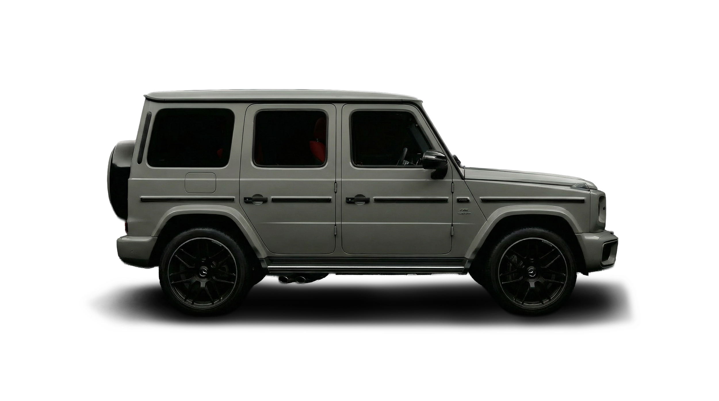 Side view of a silver Mercedes-Benz G-Class SUV with black wheels and red interior accent, isolated on black background.