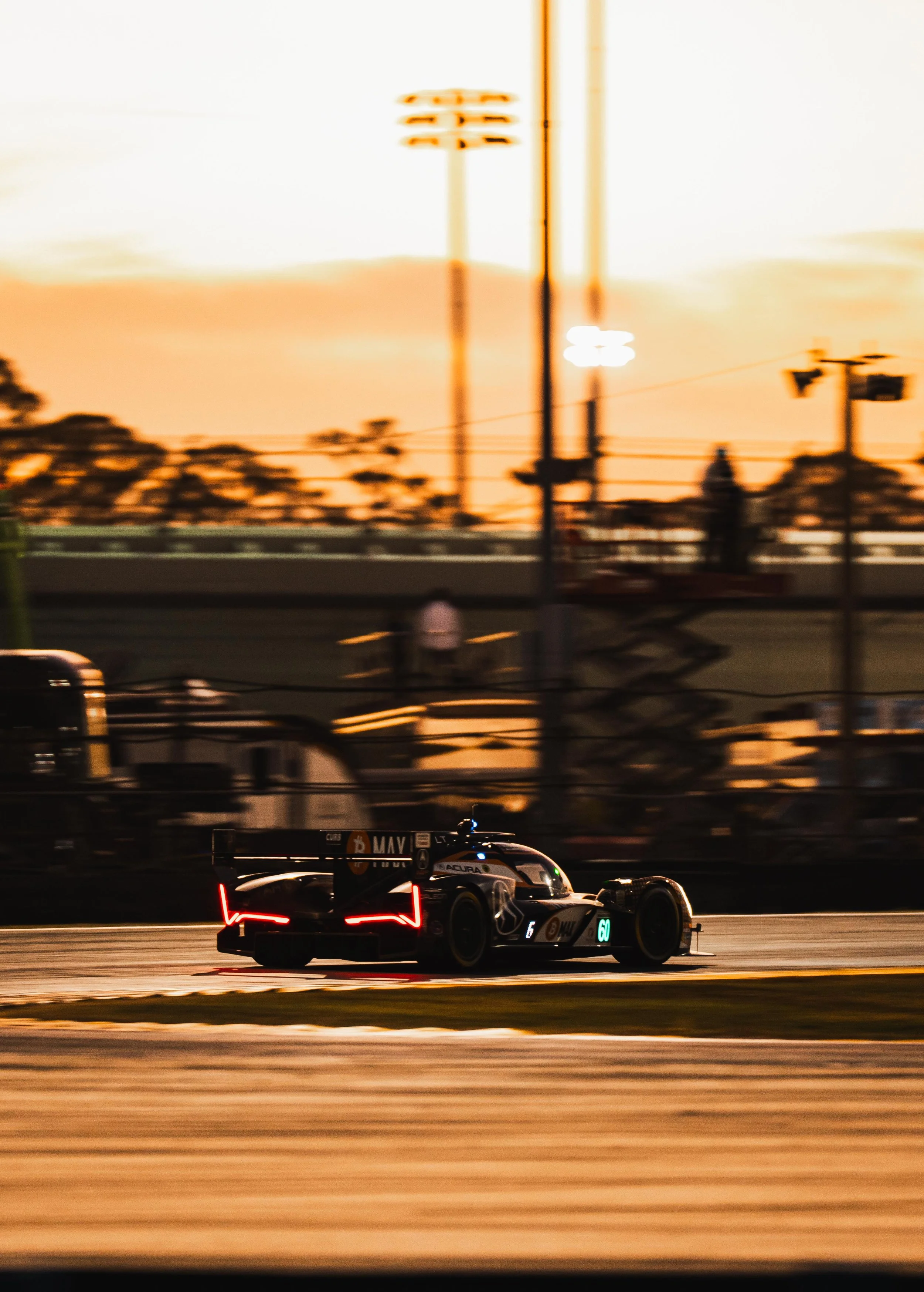 A race car on a track during sunset.