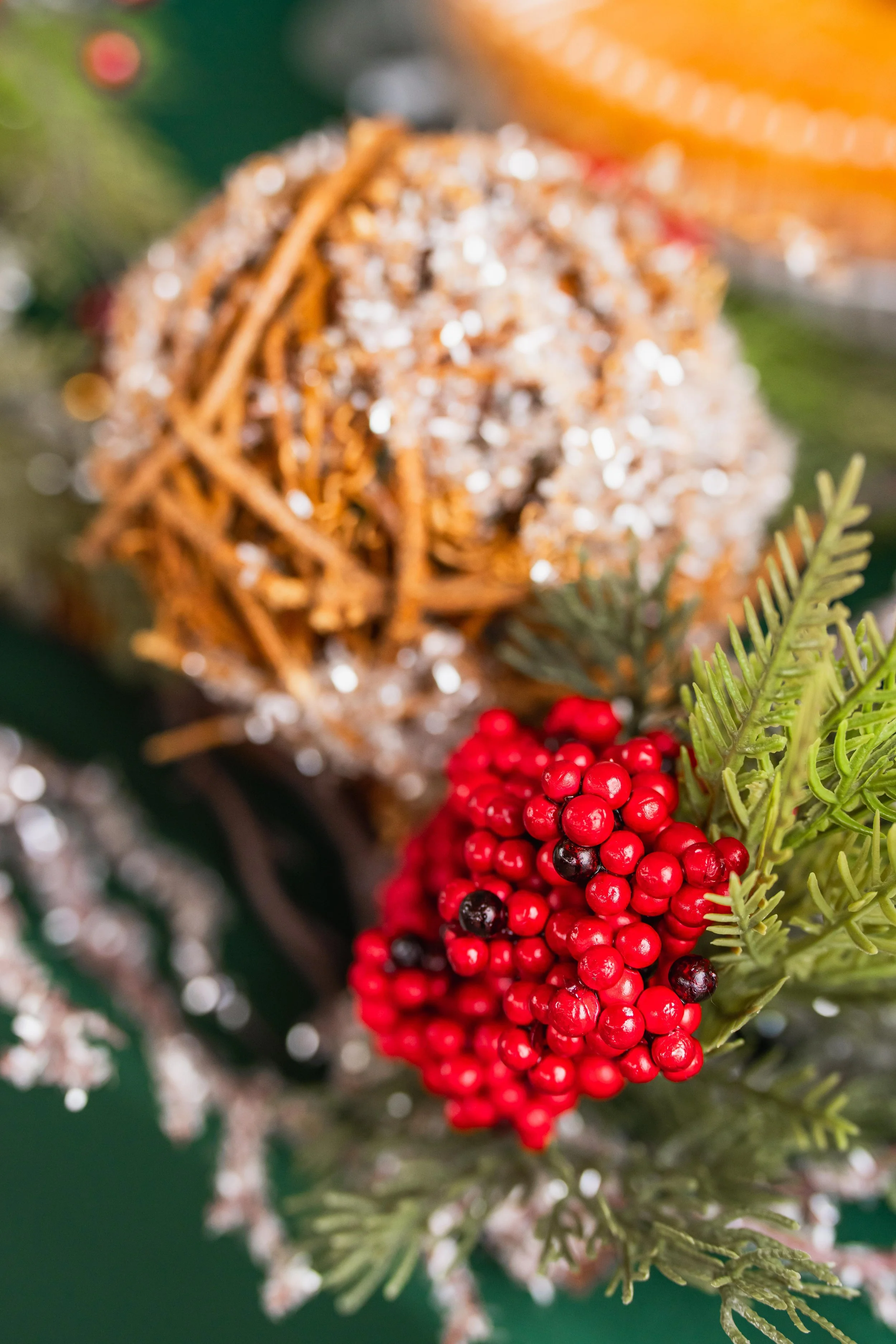 Close-up of a Christmas decoration featuring a pinecone, red berries, and greenery.