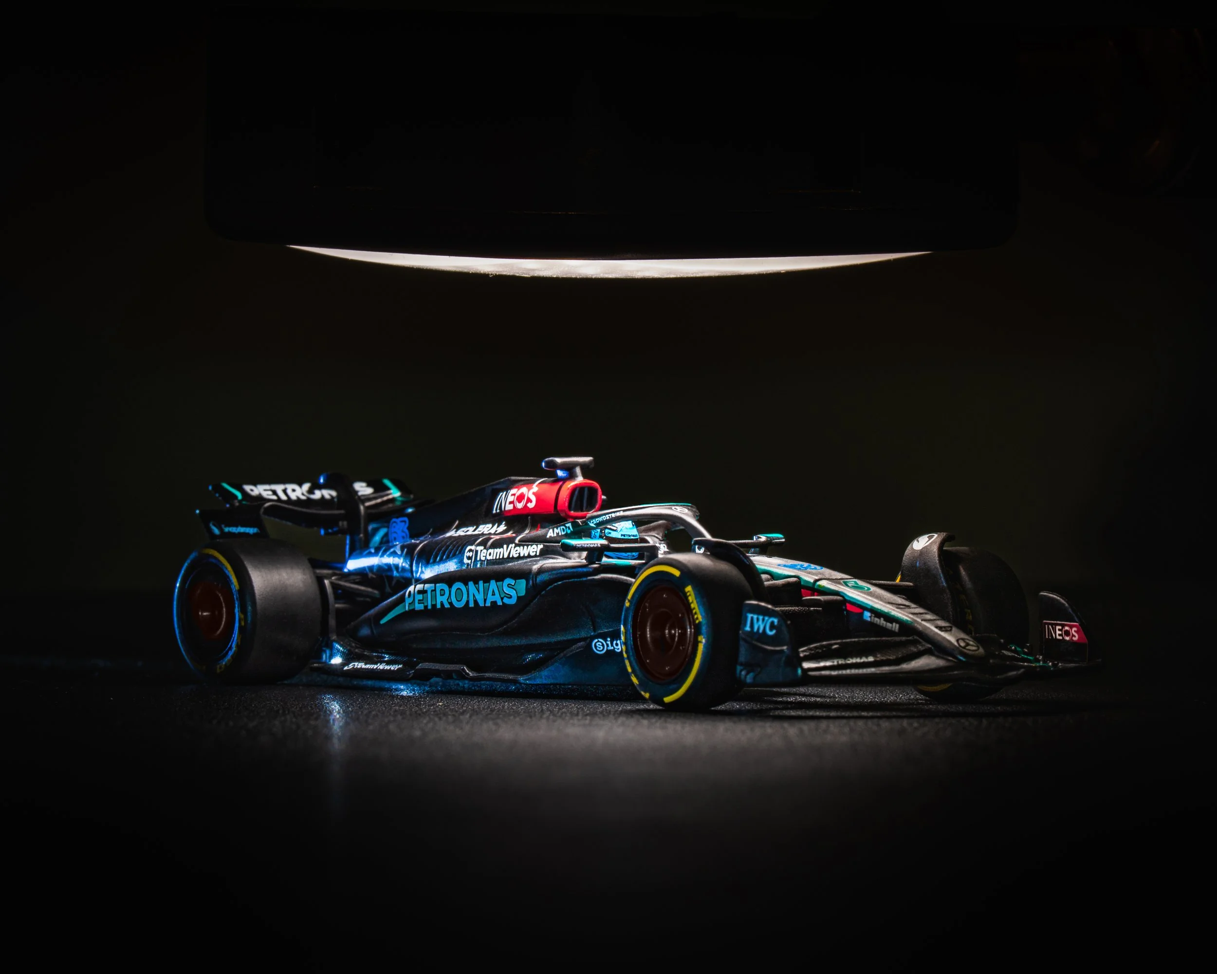 Formula 1 race car under spotlight in a dark environment