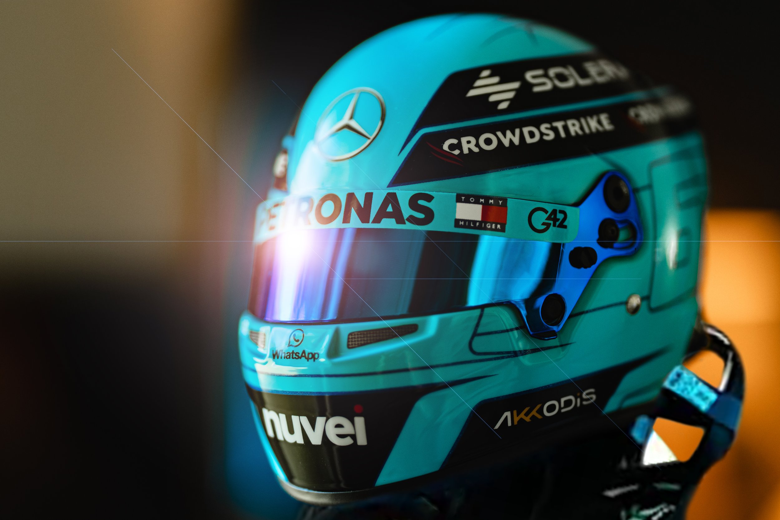 George Russell Formula 1 racing helmet with lens flare on visor. Mercedes AMG Formula 1