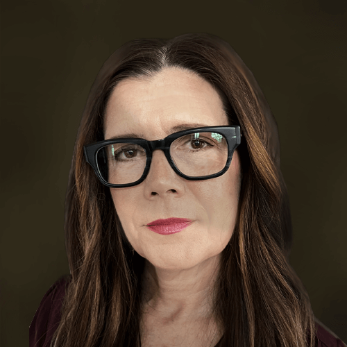A woman with long brown hair wearing large black glasses and a dark top