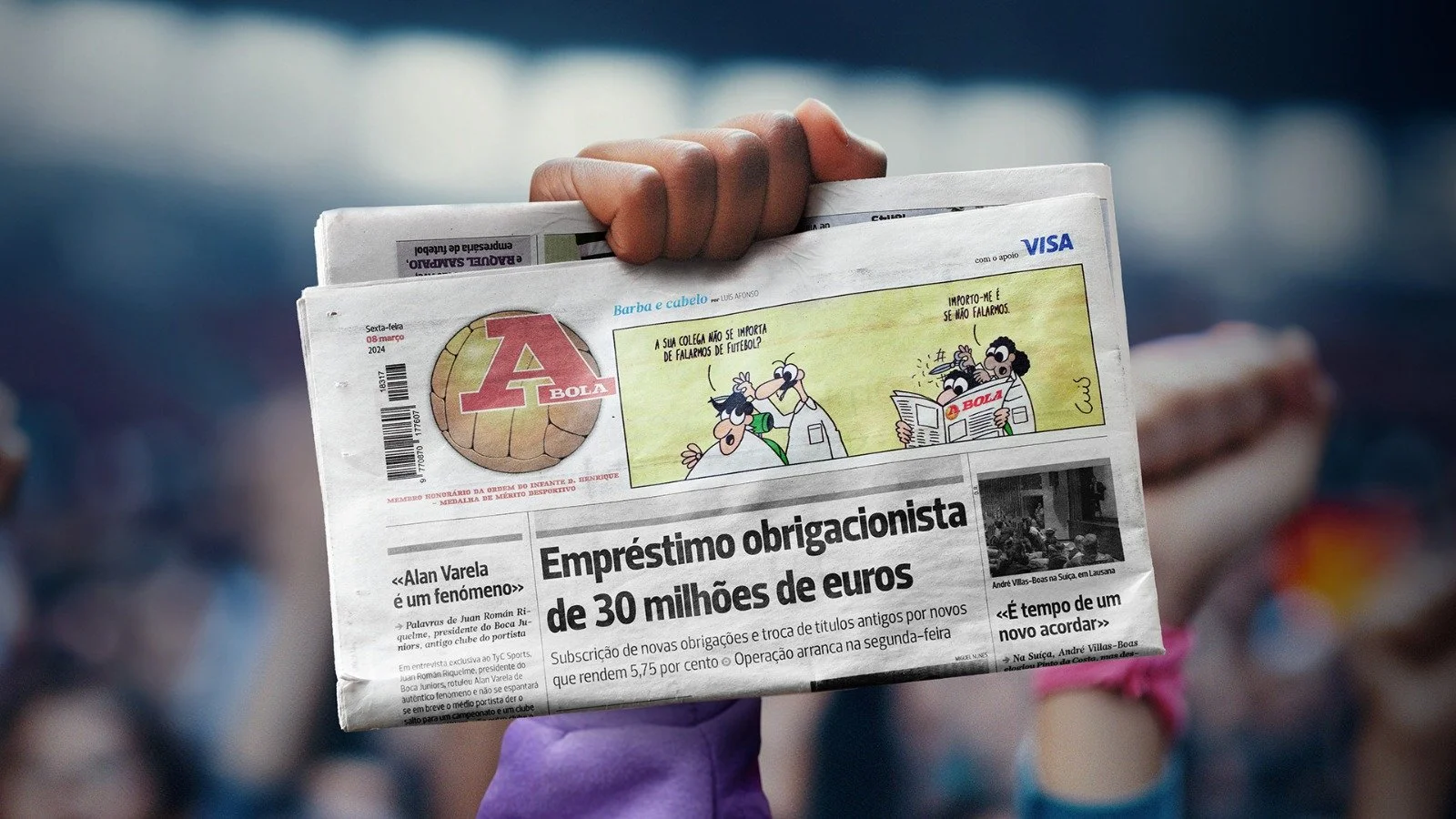 Person holding a newspaper with sports news and cartoon comic strip on top, in an outdoor setting.