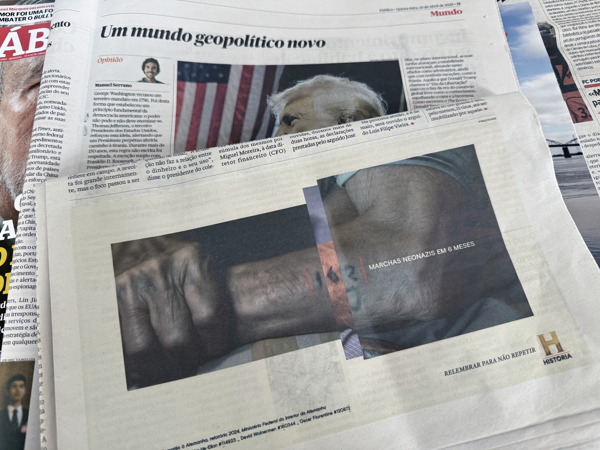 Close-up of a newspaper page featuring an article with a large photo of a newborn baby's feet and a smaller inset photo of a person, with some text overlay. There are other articles and images partly visible around it.