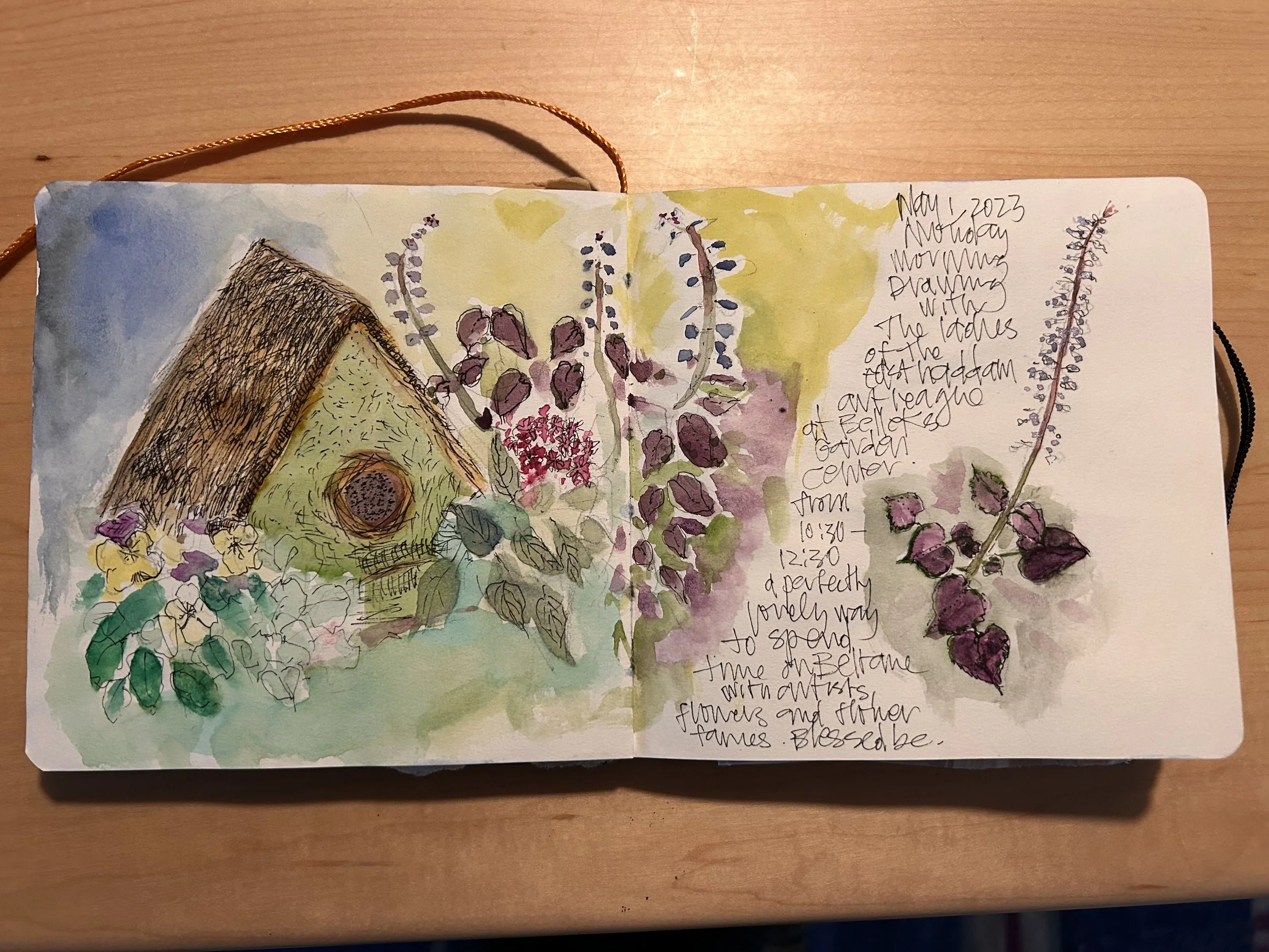 A watercolor and ink illustration of a garden scene with colorful flowers, purple and yellow lupines, and a small thatched-roof hut. Handwritten notes describe the scene and date, August 2023. Nancy DeNicolo Mindful Nature Journaling