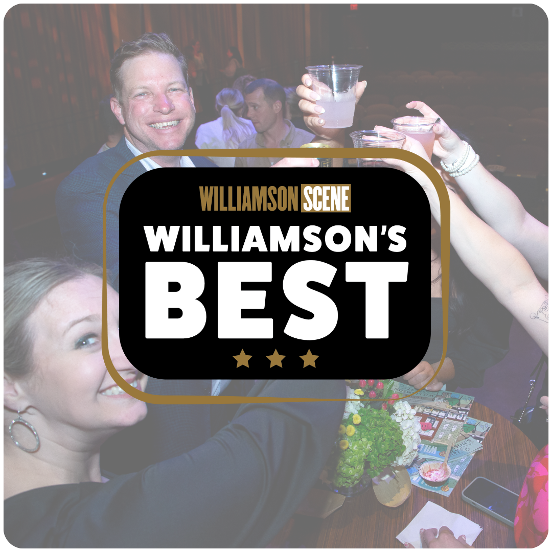People celebrating and raising drinks in a social gathering at Williamson's Best, with smiles and a decorated table.