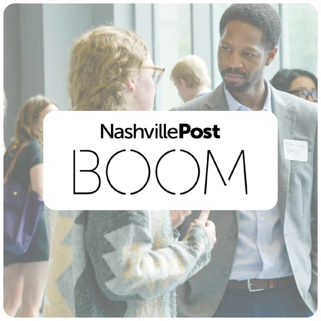 People having conversations at a networking event with signs and name tags.