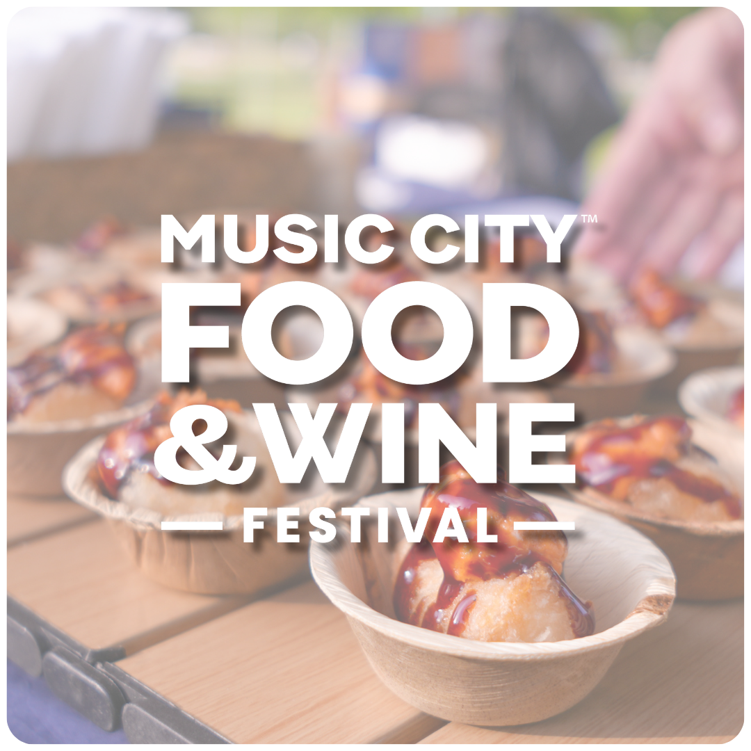 Disposable bowls containing food with sauce on top at a food festival with a blurred background.