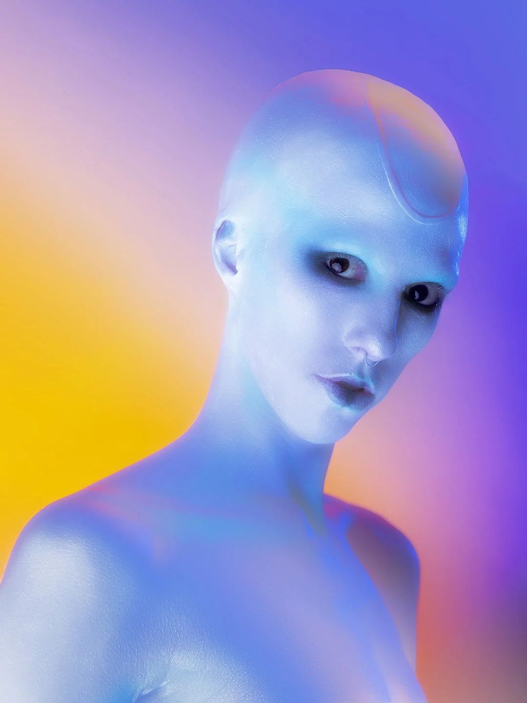 A futuristic person with a bald head and pale skin, illuminated by colorful, vibrant lighting in shades of purple, pink, yellow, and blue. The person has striking eyes with a mysterious gaze.