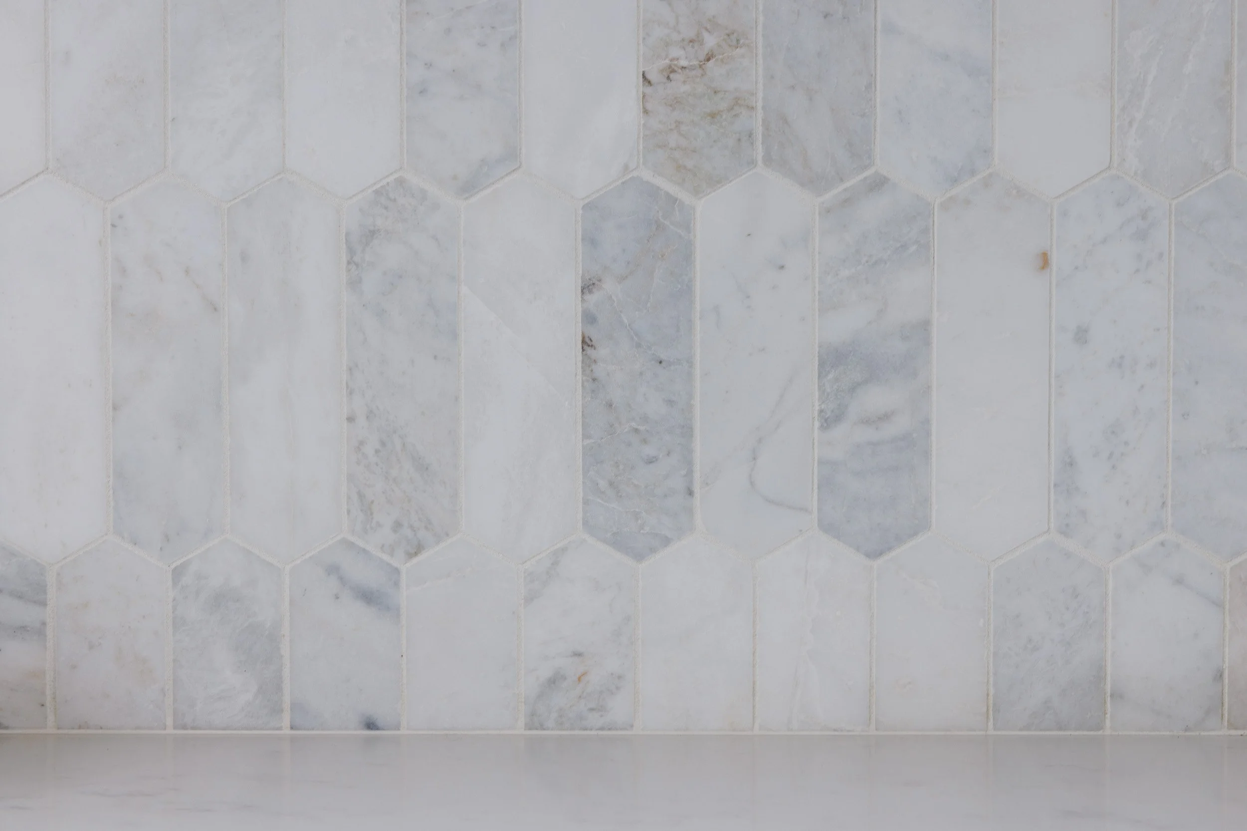 A section of a gray tiled kitchen backsplash. Used as a background for the testimonials section.