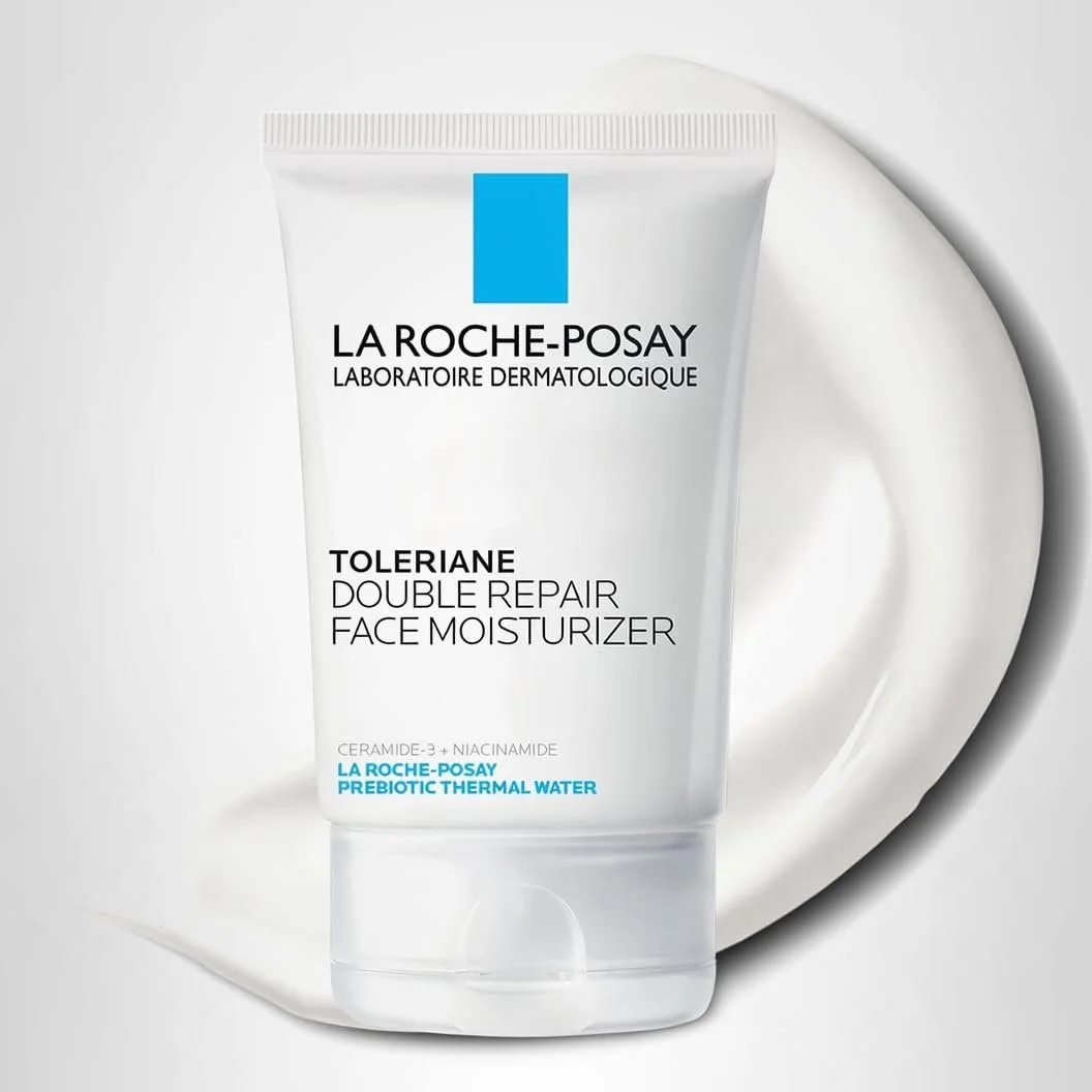 A tube of La Roche Posay Toleriane Double Repair Face Moisturizer on a white background with a swatch of moisturizer behind it.