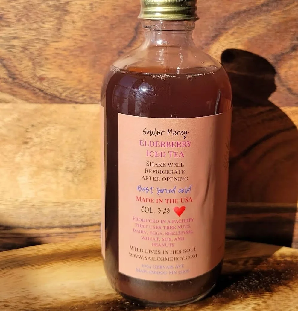 Side view of elderberry iced tea bottle with product details and handcrafted small-batch label