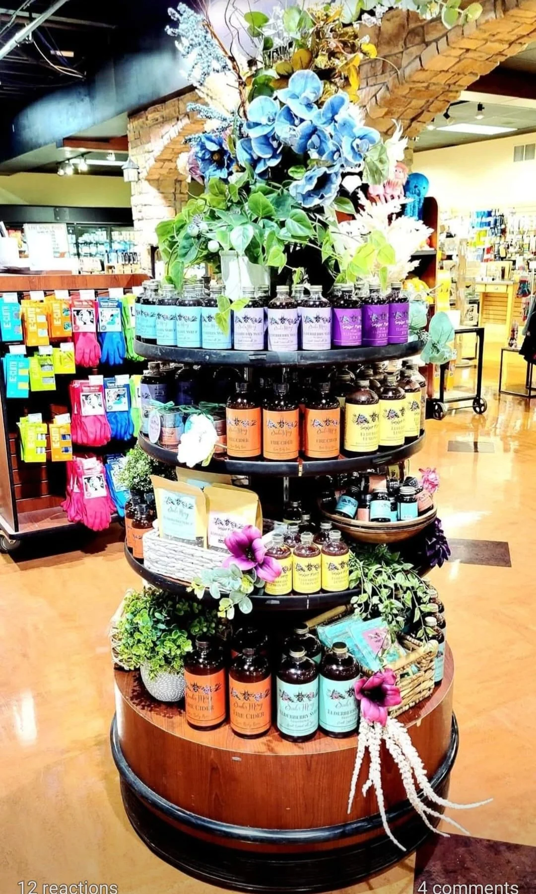 Display of colorful bottles and plants on a multi-tiered wooden stand in a store