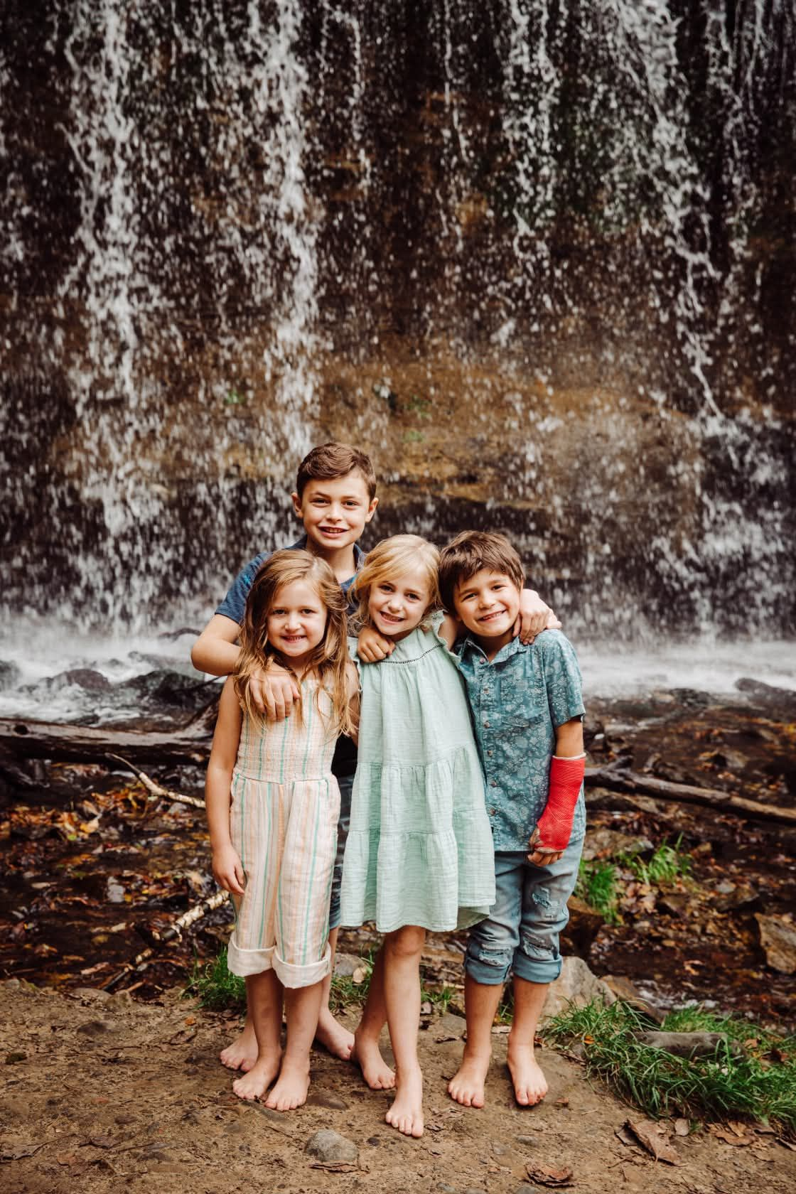 Children of Sailor Mercy founder exploring outdoors by a waterfall