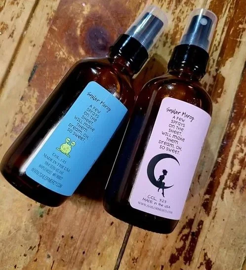 Essential oil sleep sprays by Sailor Mercy including Princess and Dragon Slayer calming bedtime mist in amber glass bottles