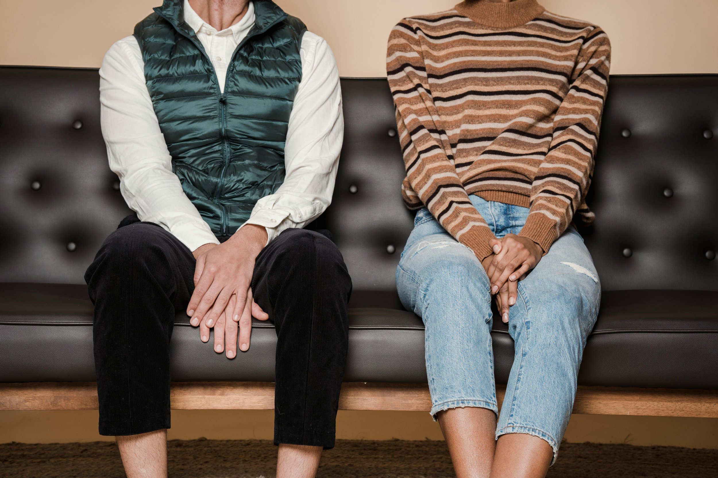 A couple sitting apart on a sofa, reflecting emotional distance explored in relationship counselling.