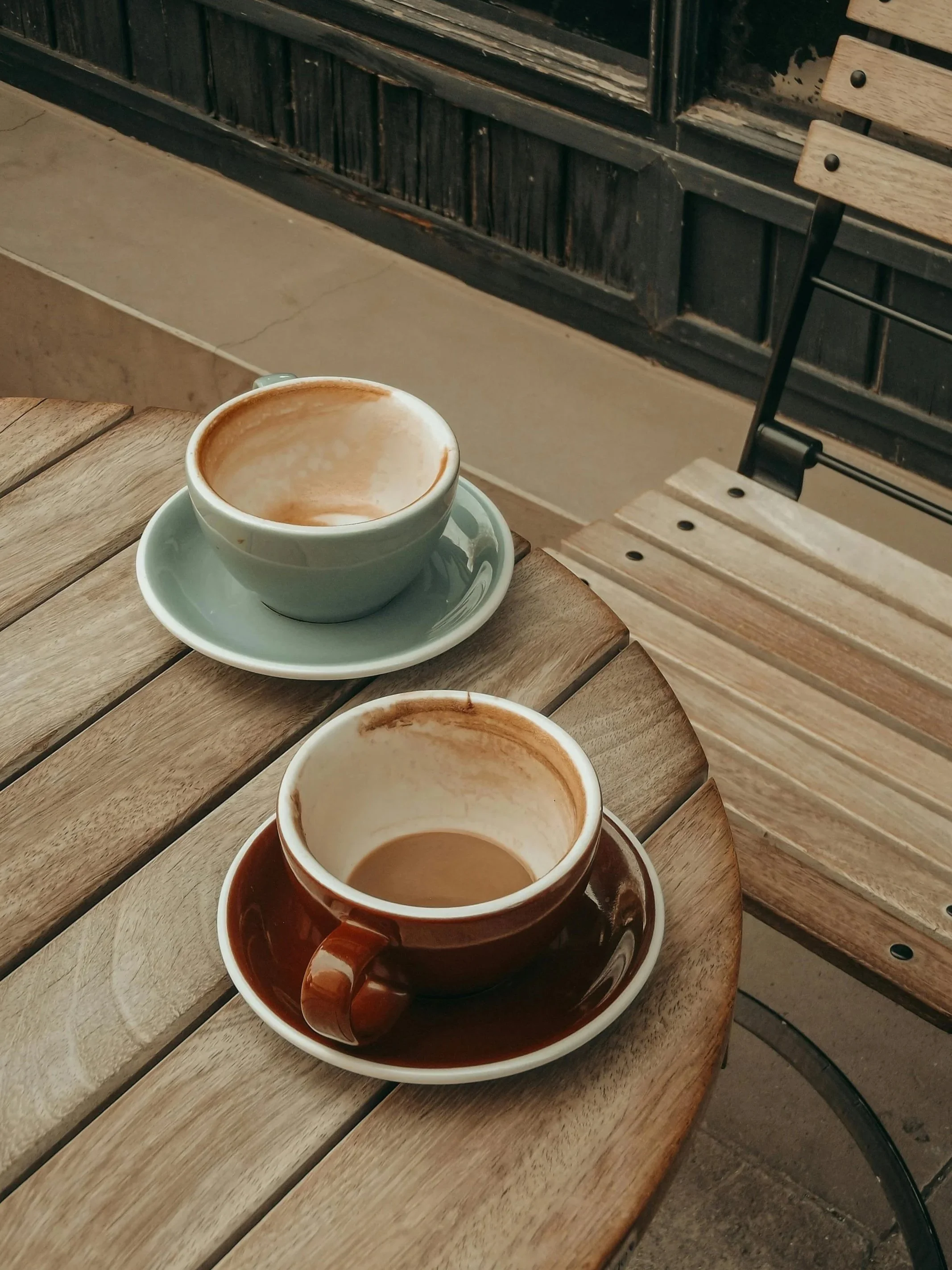 Two empty coffee cups on a wooden table representing the exhaustion of repetitive cycles in relationships. Reflectful Counselling offers couples and relationship therapy in Norwich