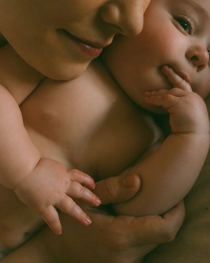 Close-up of a mother breastfeeding her young child, with both sharing an intimate moment.