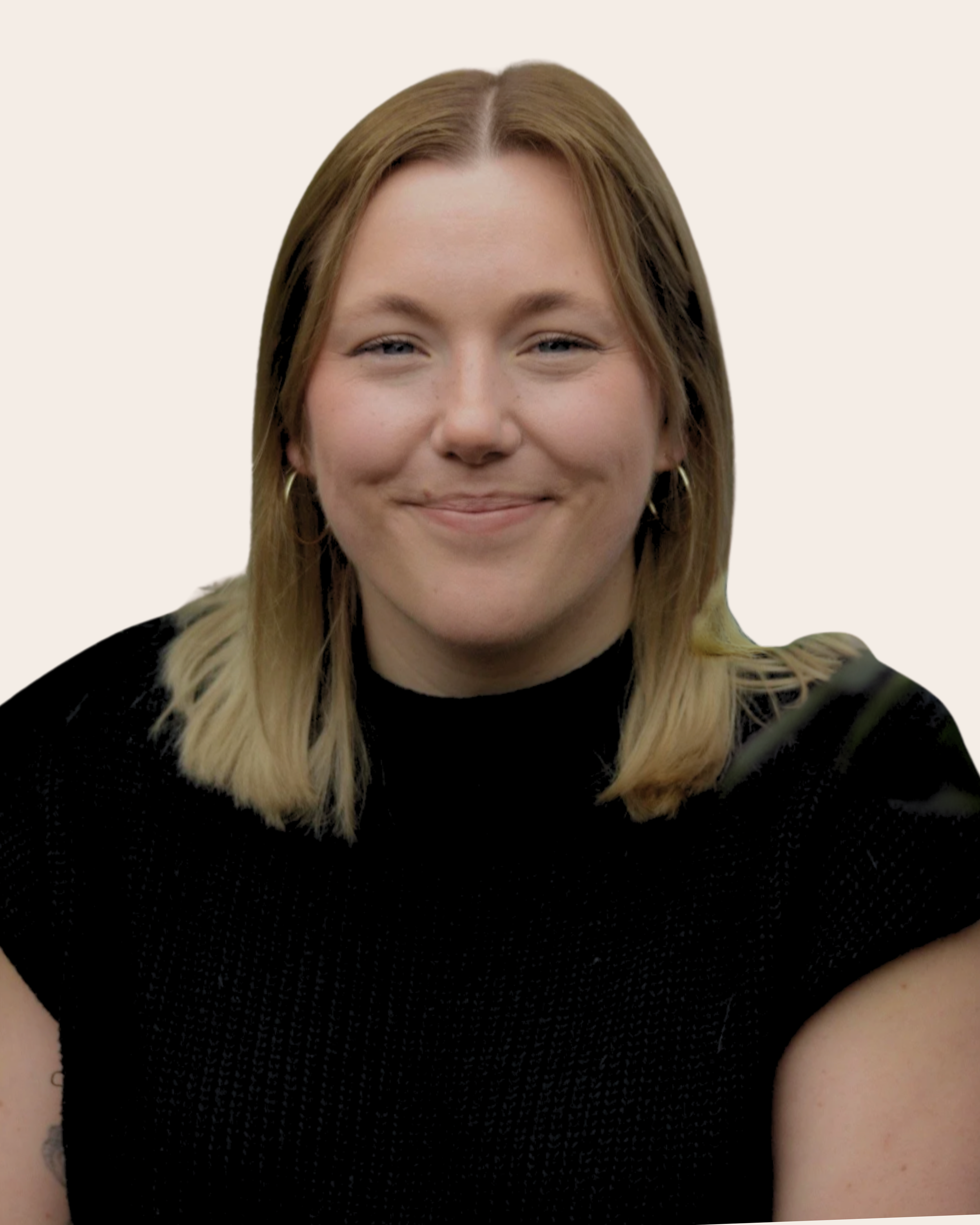 A woman with shoulder-length blonde hair, wearing a black top, smiling against a plain light background.