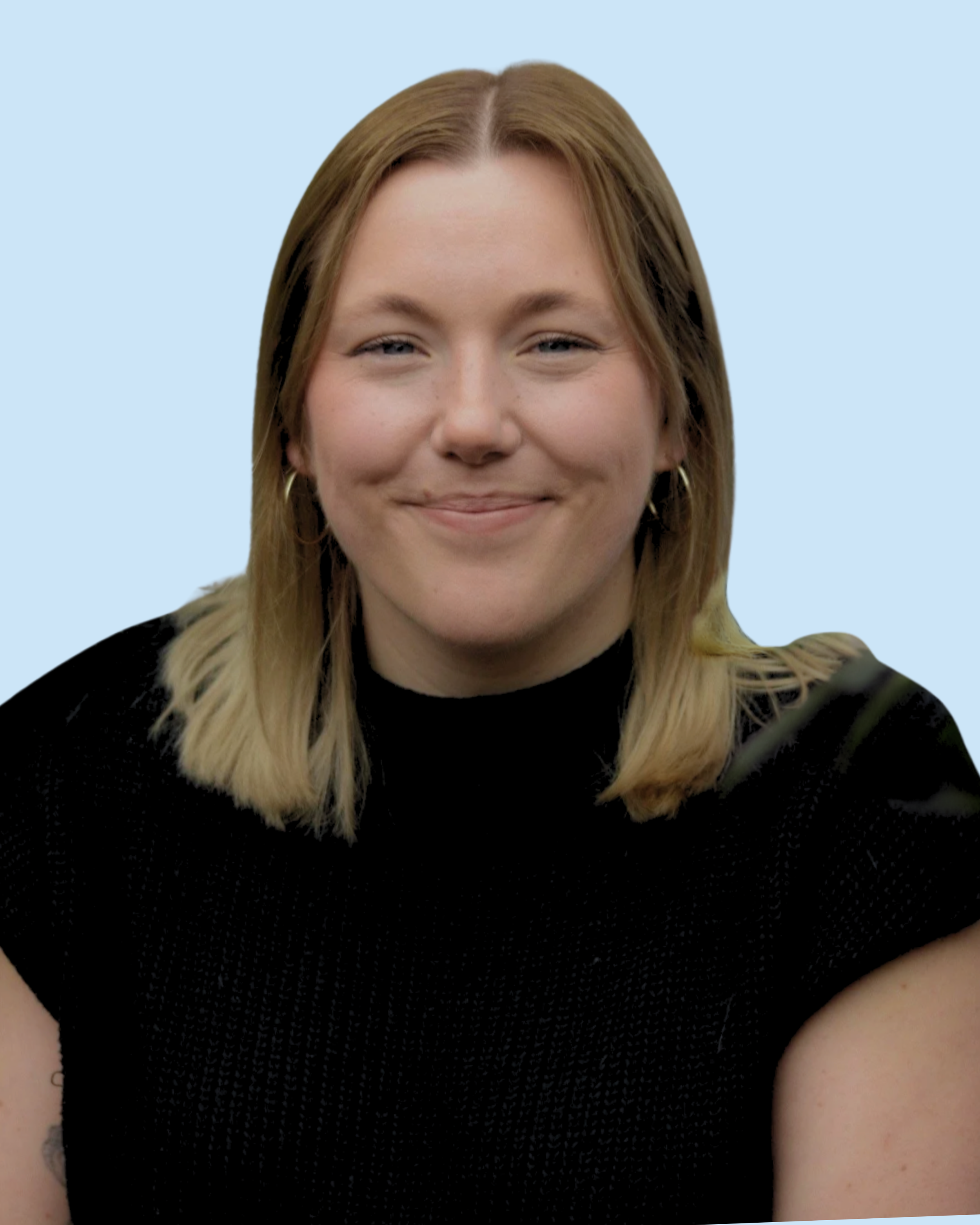 A woman with shoulder-length blonde hair, light skin, and wearing a black top, smiling at the camera against a light blue background.