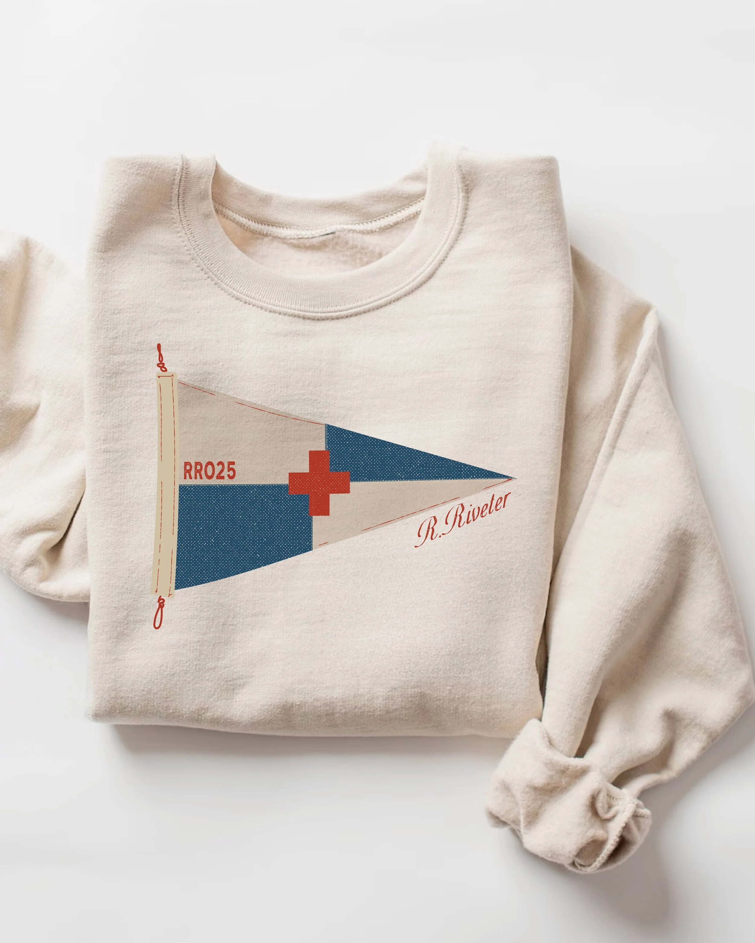 Cream-colored sweatshirt featuring a nautical flag with a red cross, labeled RRO25, with red text 'R. Riveter' and a red cross symbol.