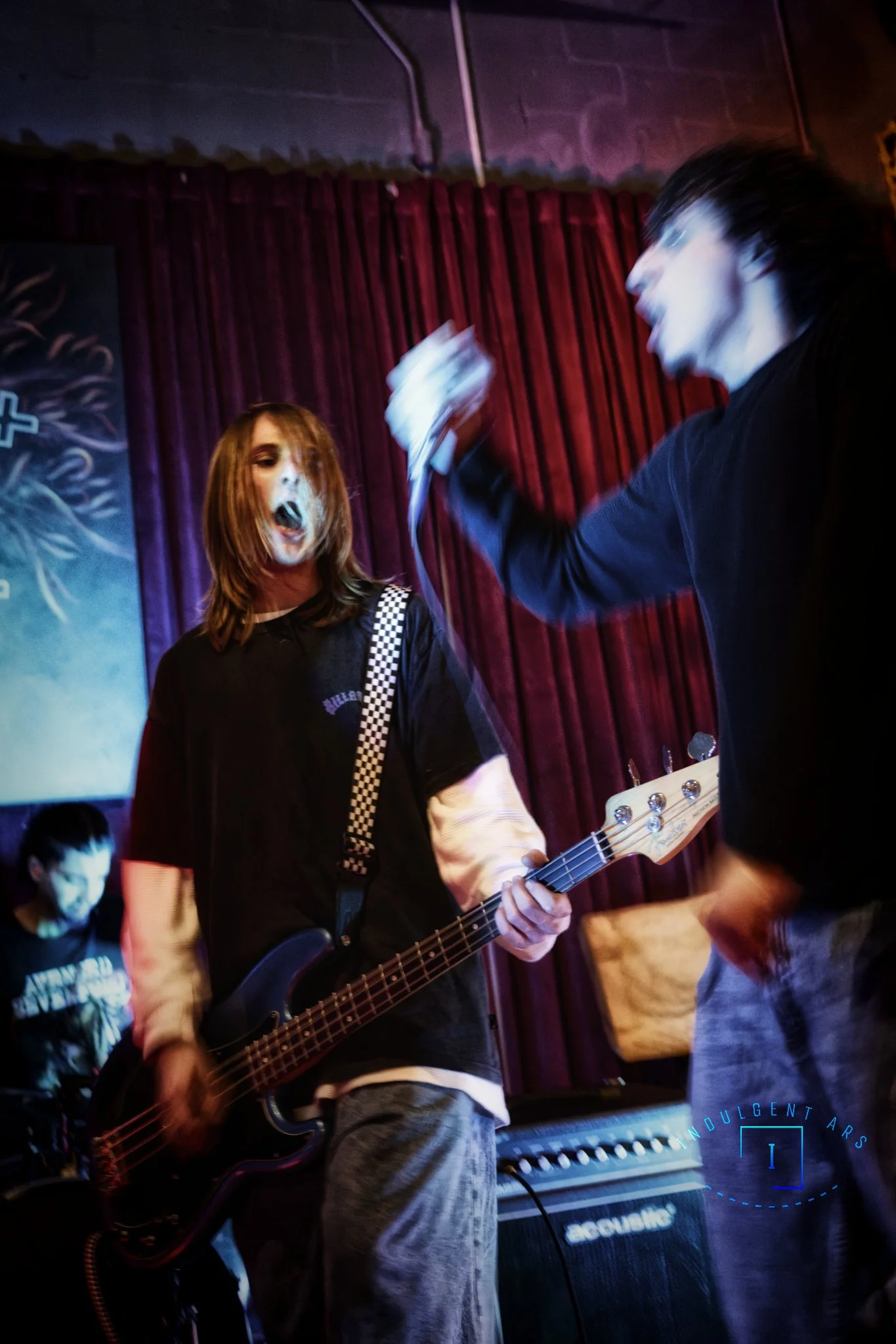 The Librarians' bassist just finish a vocal piece, as the lead bring the mic back to continue. The bassist is still heavily into the vocal part during the transition.
