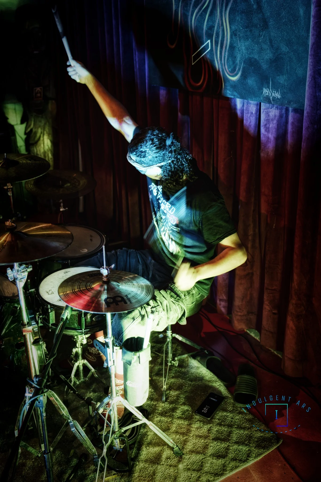 The Librarians' drummer is showing of his skills by drumming blindfolded. 