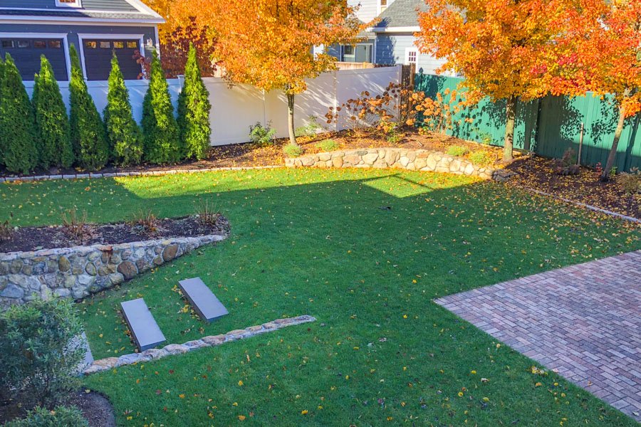  Bluestone pavers with turf joints for seating area with evergreen screening shrubs  