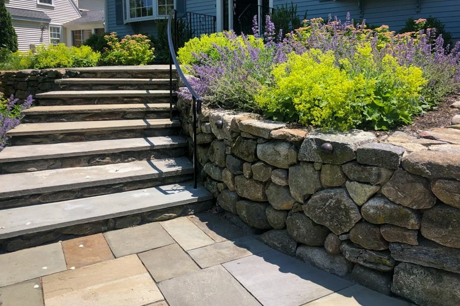  Curving gracious steps with light wrought iron handrail and stone retaining wall 
