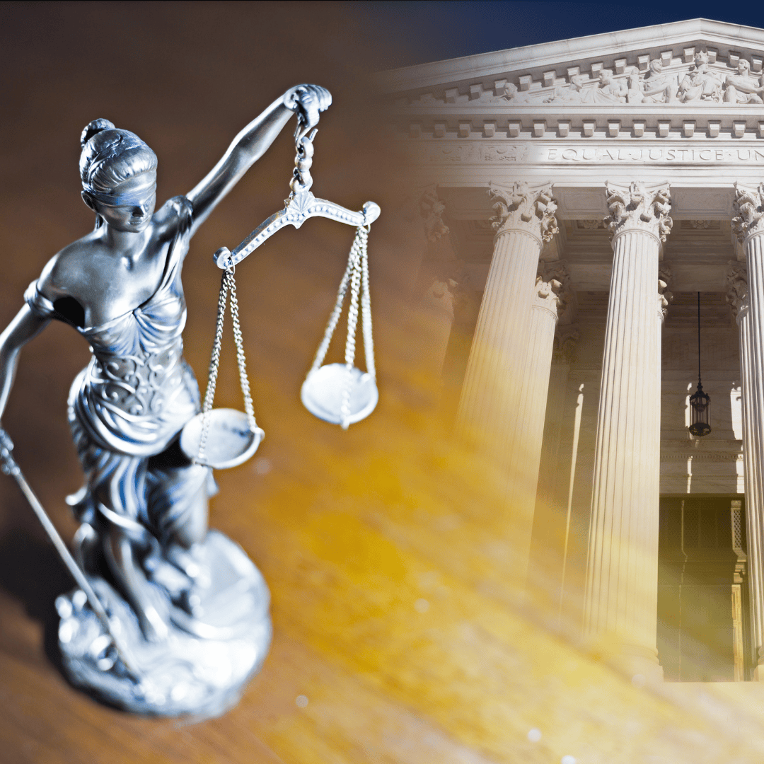 A metal statue of Lady Justice holding scales in front of a courthouse with large columns.