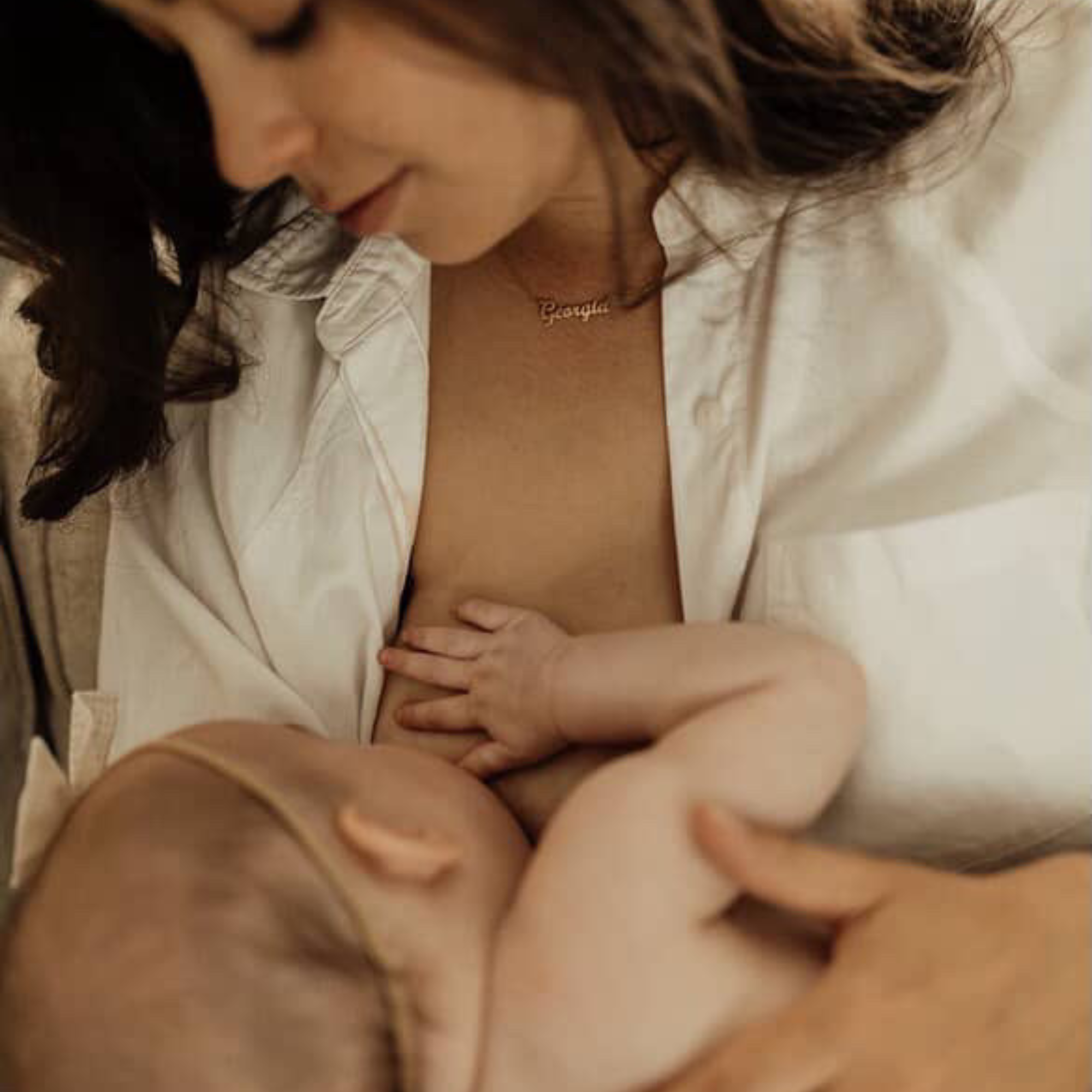 Mother breastfeeding an infant while lying down, highlighting gentle bonding, skin-to-skin contact, and natural feeding support in a calm home environment