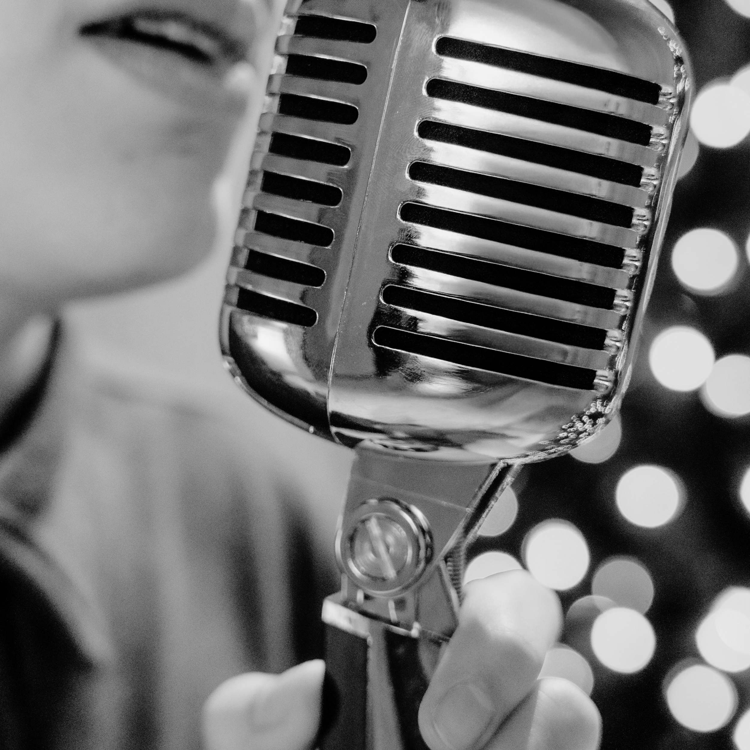 close up of mic, black and white photo, with a segment of Gavin's face in background