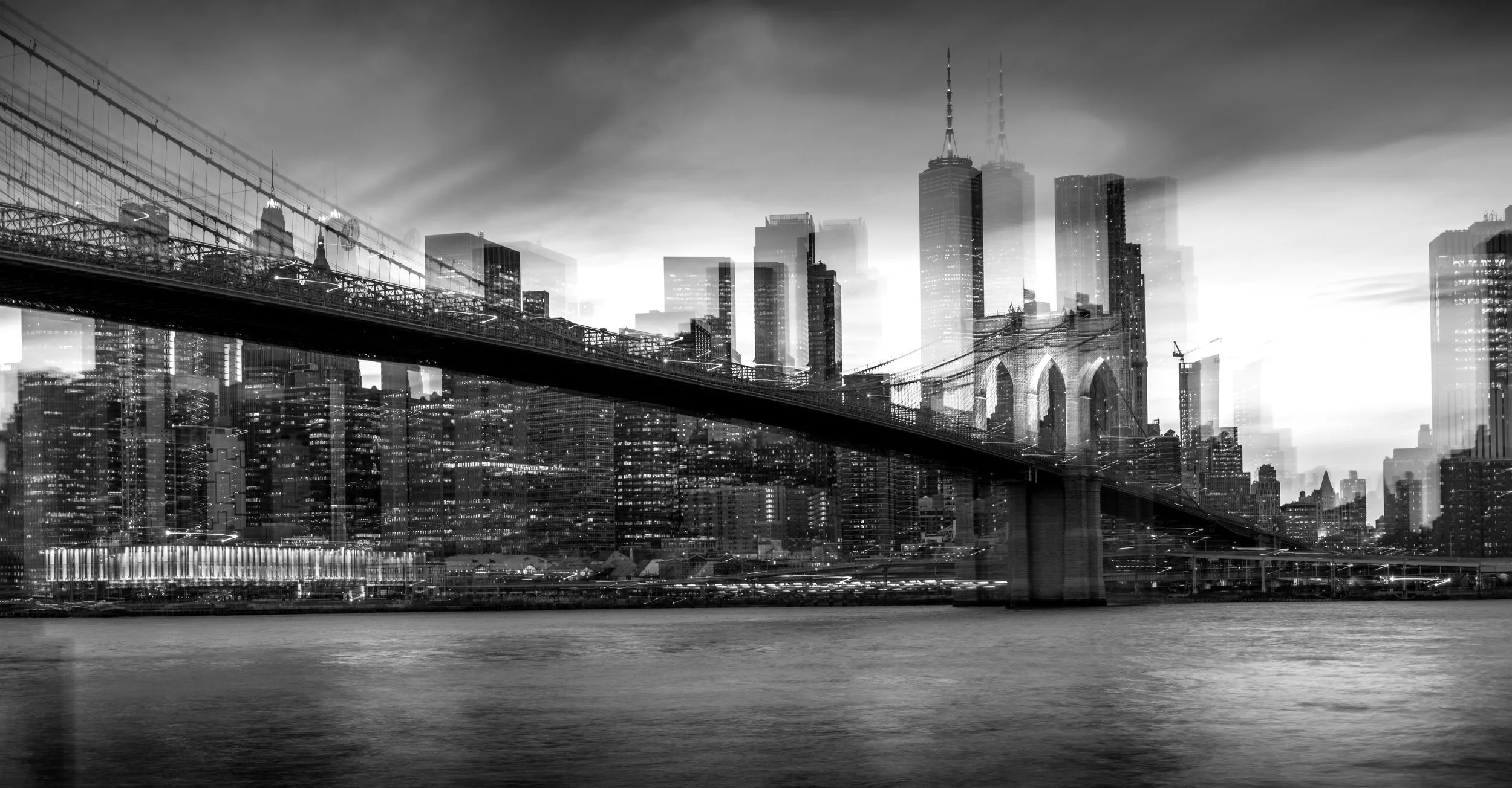 Une silhouette d'une ville avec des gratte-ciel, un pont suspendu et un fleuve en premier plan, en noir et blanc.