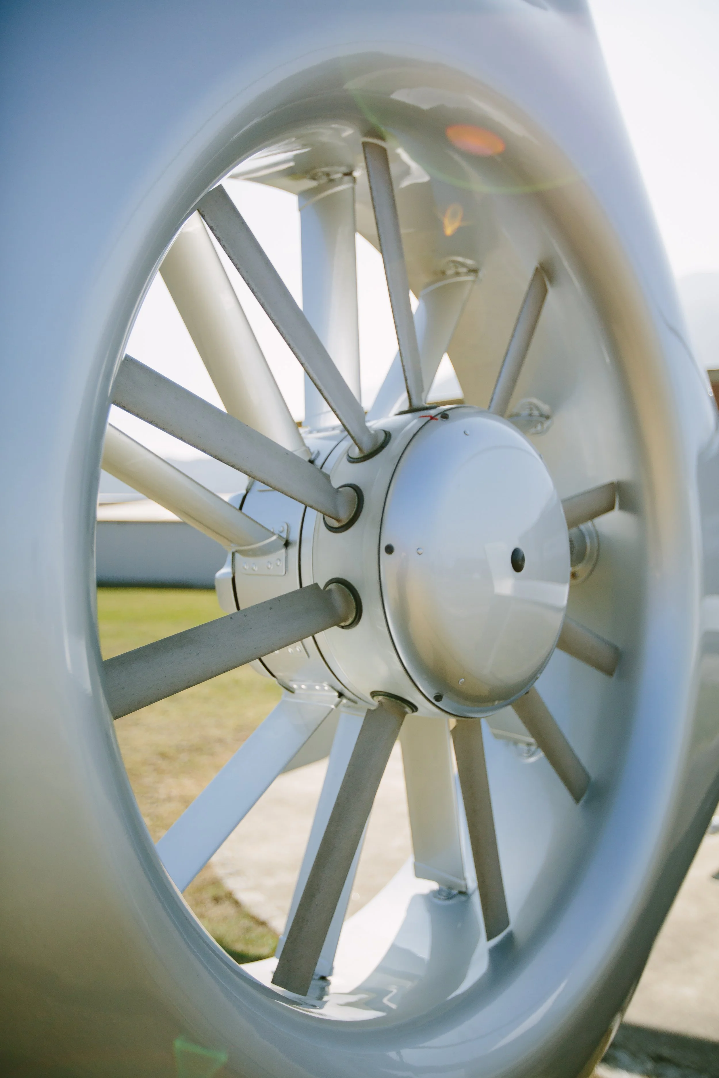 Close-up view of a modern aircraft wheel, showing the hub and spokes with a clear sky background.