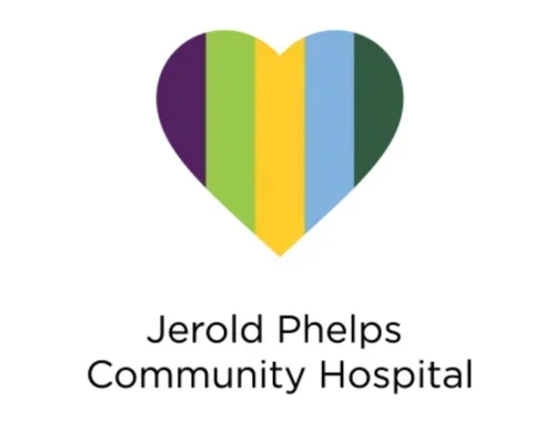 A heart-shaped logo with vertical rainbow stripes in purple, green, yellow, light blue, and dark blue, with text below that reads 'Jerold Phelps Community Hospital'.