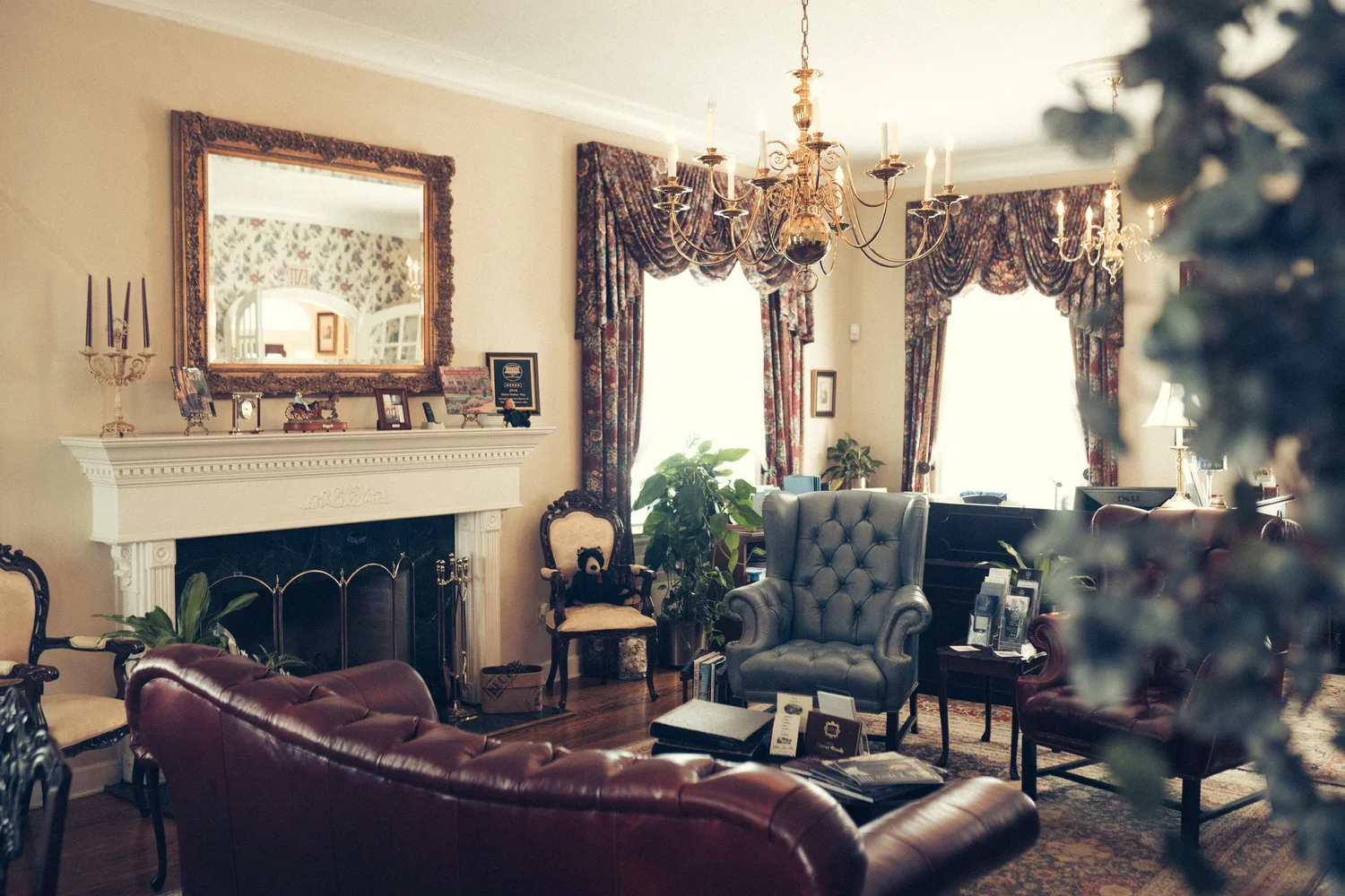 A parlor inside Mann Manor with a fireplace and period furnishings, where Sutton Law Firm meets with clients