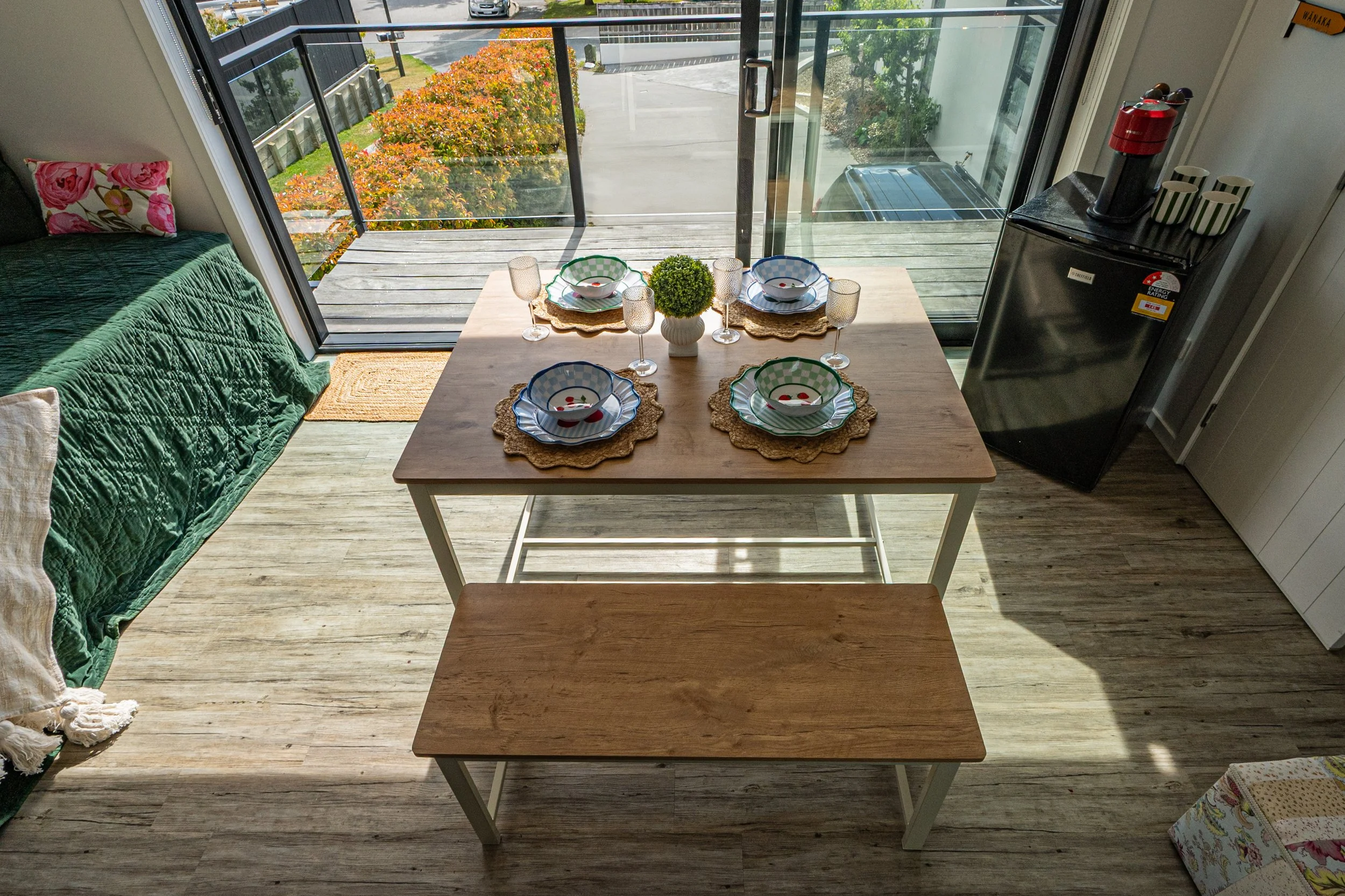 Dining area with a table set for four, Wanaka Air BNB in a quiet cul-de-sac setting close to Wanaka Township. Alpine and mountain views. Equipped with a Nespresso coffee machine and a 10kg washing machine. Balcony and dining area. 