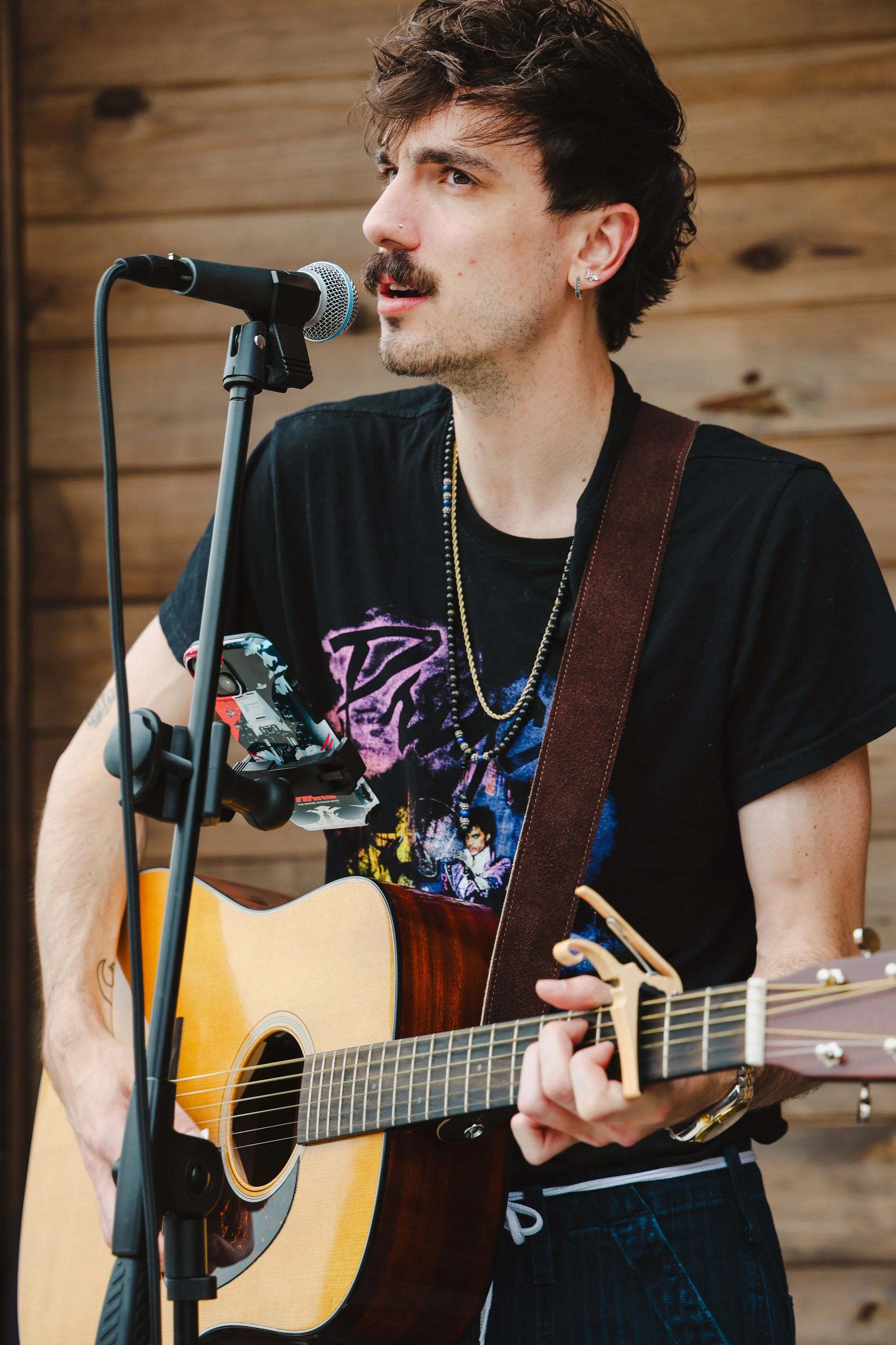 Peyton Kyle singing at microphone with guitar