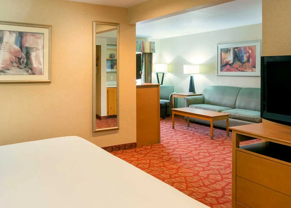 King suite hotel room with king sized bed, sitting area with pull-out sofa and a private balcony