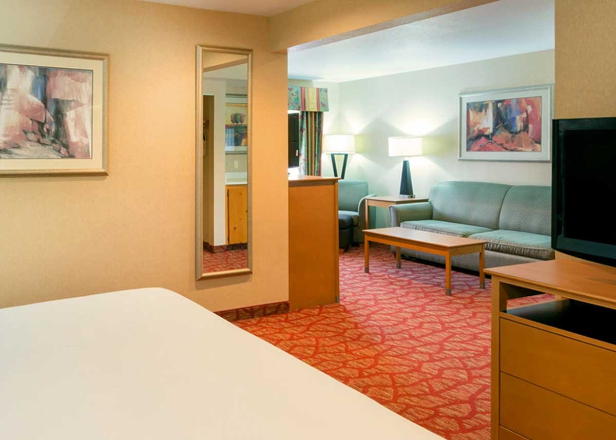 King suite hotel room with king sized bed, sitting area with pull-out sofa and a private balcony