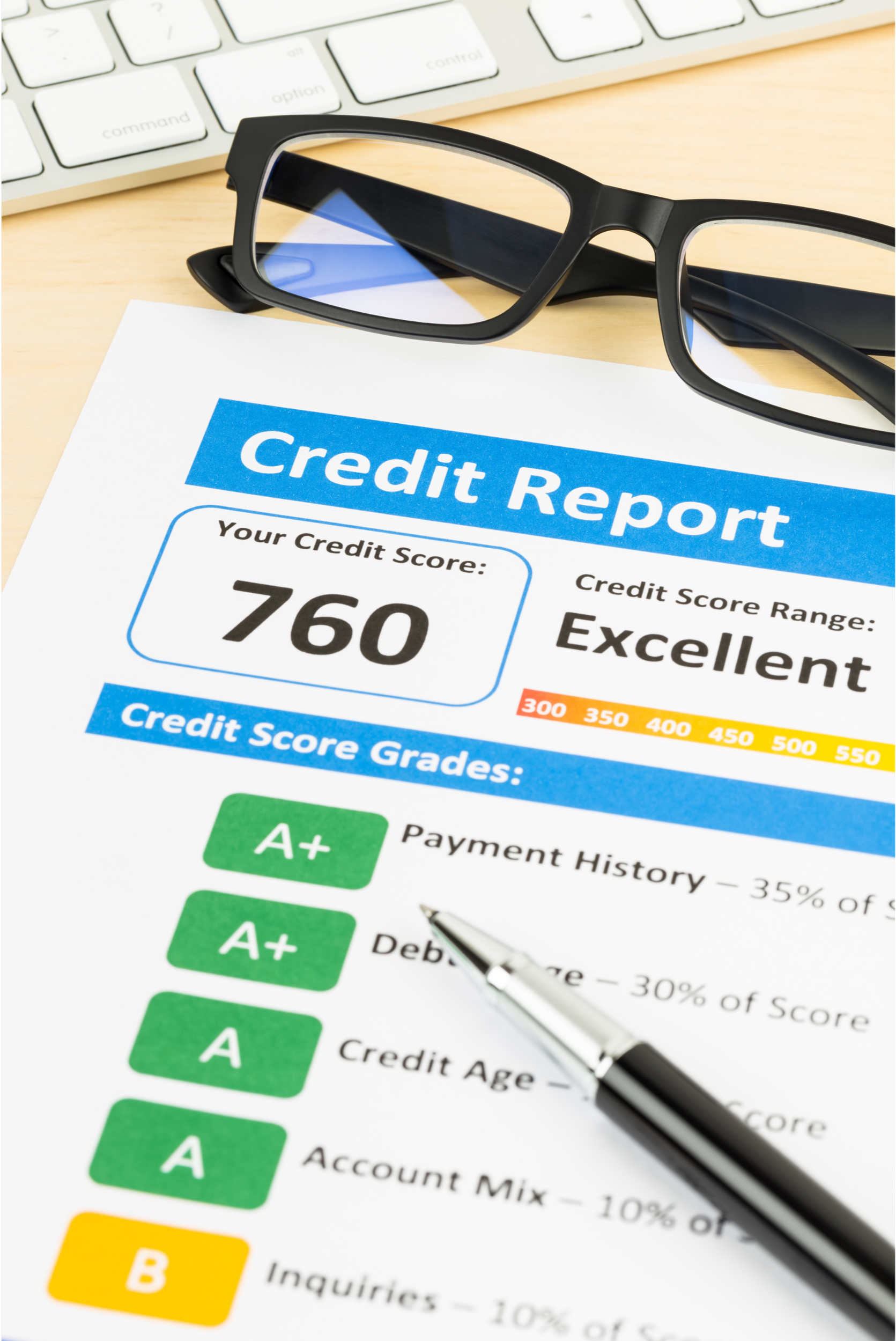 Credit report document with a credit score of 760, labeled as excellent. The document shows various grades for payment history, debt, credit age, and account mix, with green A+ and A grade markers. A pair of eyeglasses and a pen are placed on the document, and a keyboard is visible in the background.